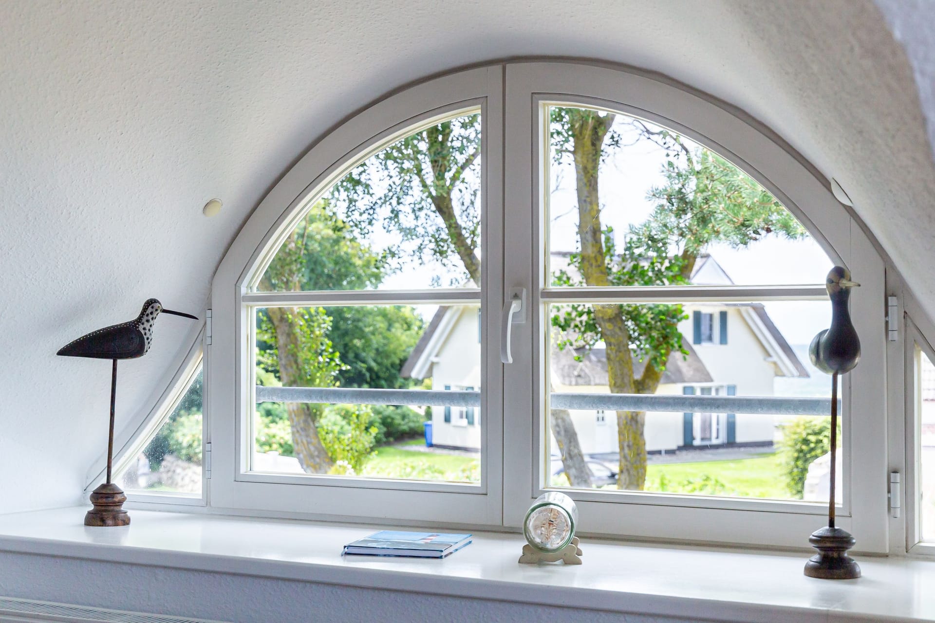 Fenster mit Blick auf den Garten und Nachbarhäuser.
