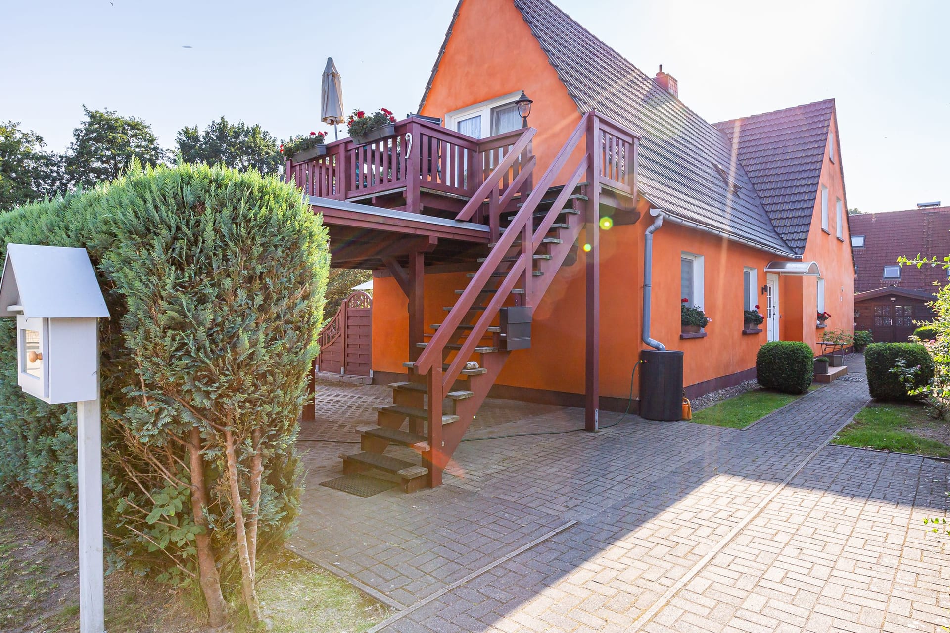 Außenansicht eines orangefarbenen Hauses mit Balkon