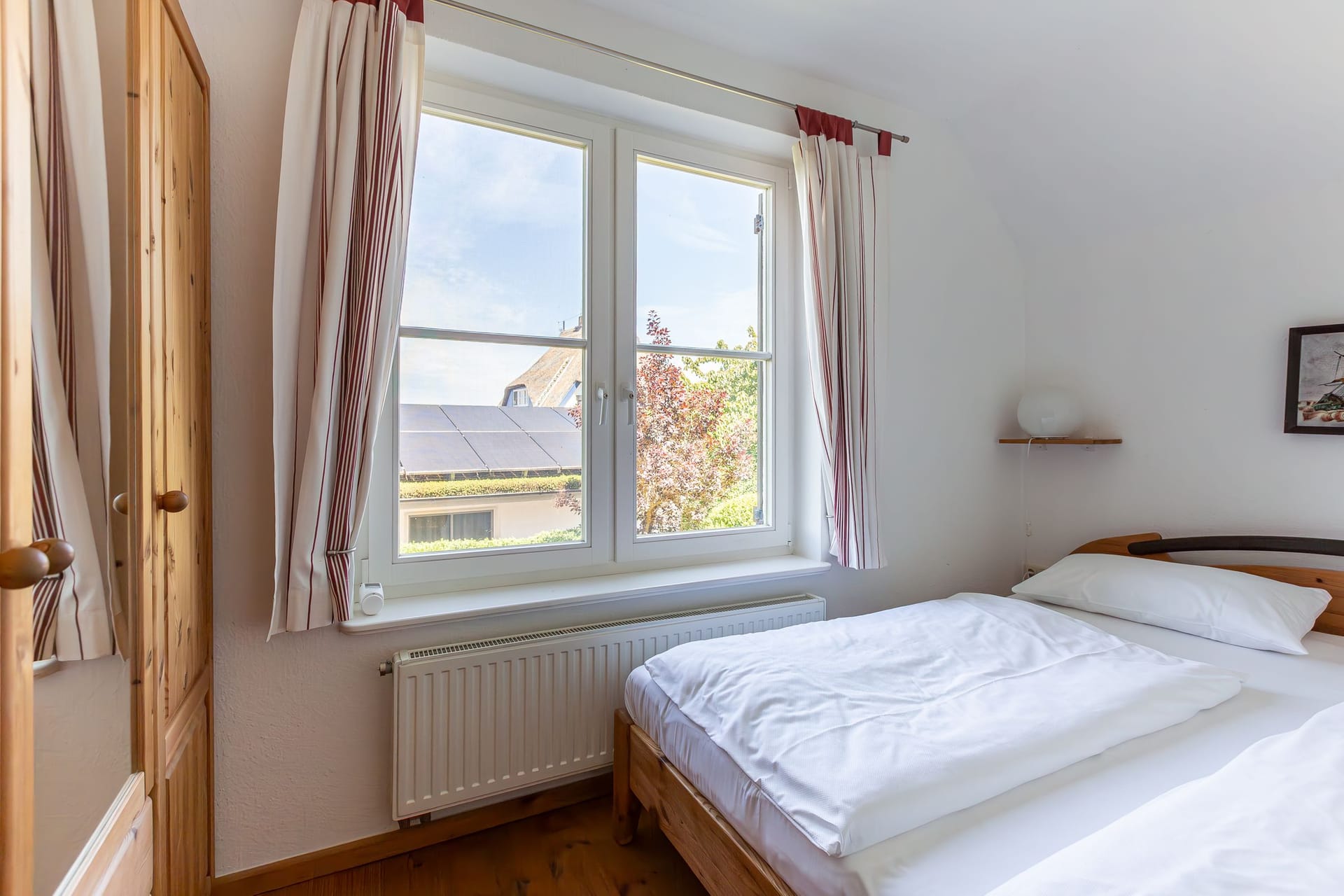 Helles Schlafzimmer mit Doppelbett und Fenstern
