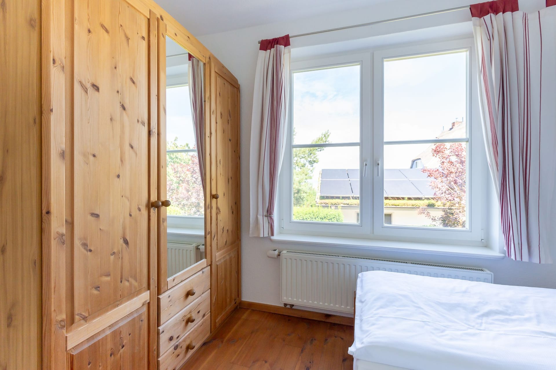 Schlafzimmer mit Holzschrank und Tageslicht