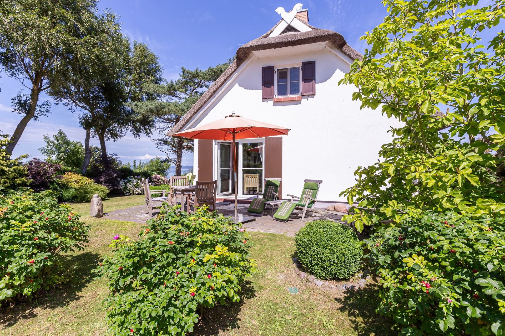 Terrasse mit Sitzmöbeln und Sonnenschutz