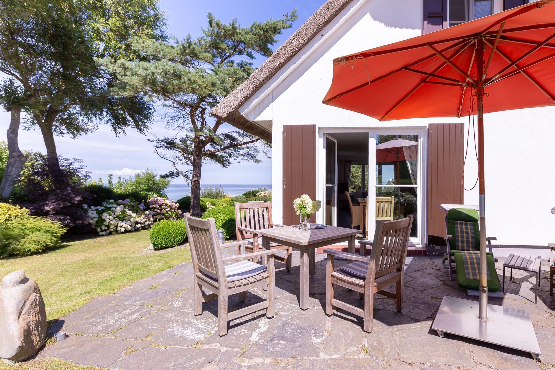 Sonnige Terrasse mit Tisch und Stühlen