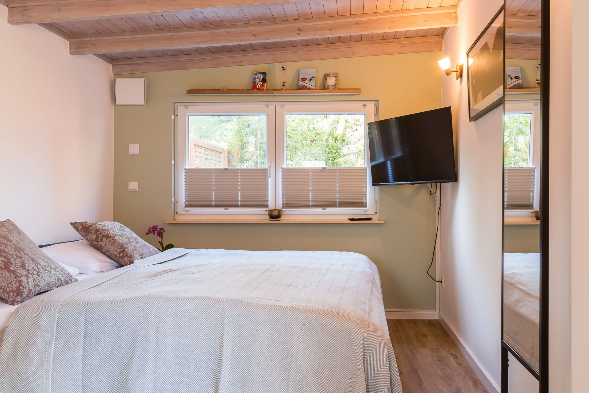 Schlafzimmer mit Doppelbett und Wand-TV