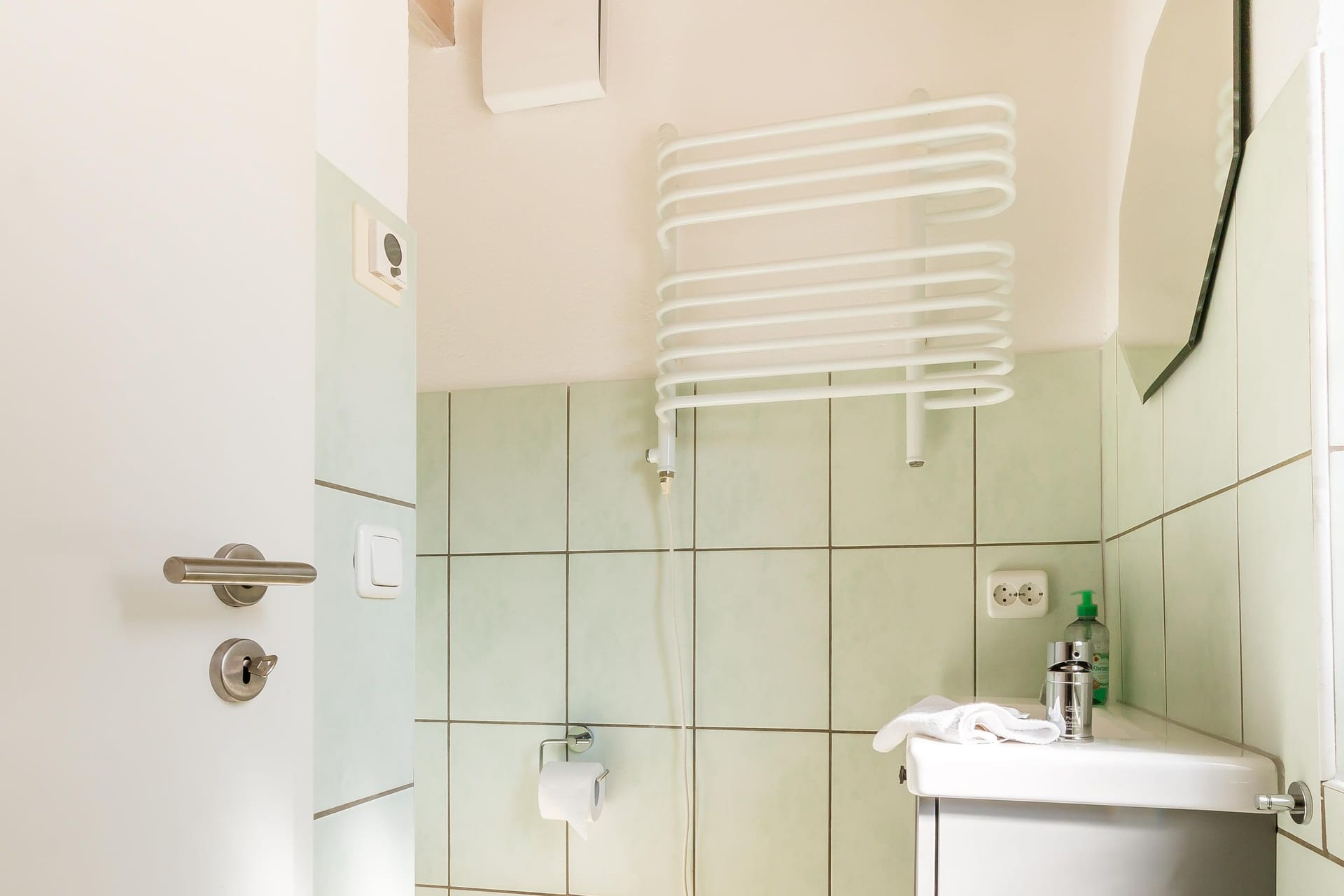 Helles Badezimmer mit Waschbecken und Handtuchhalter