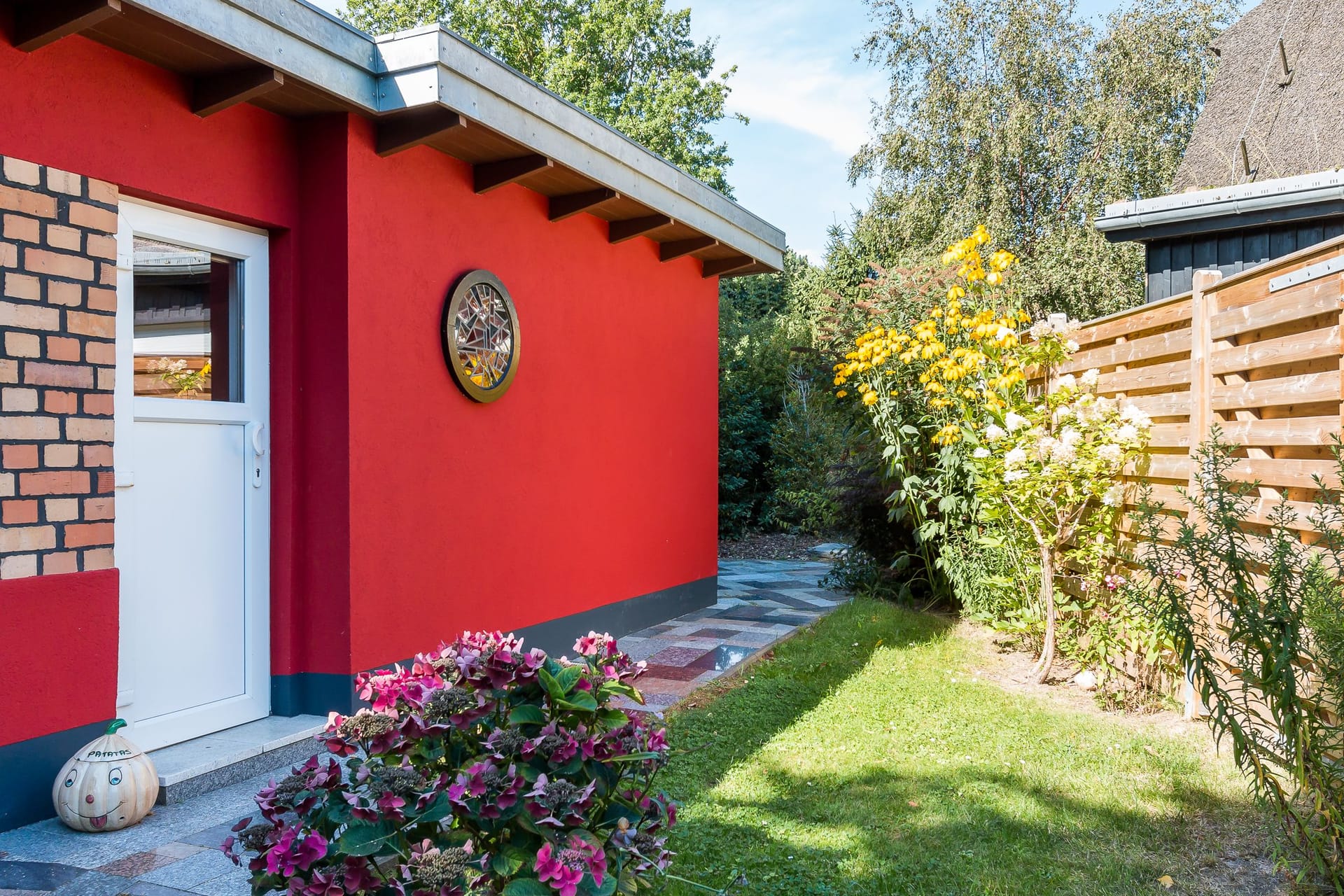 Außenansicht eines roten Gebäudes mit Garten