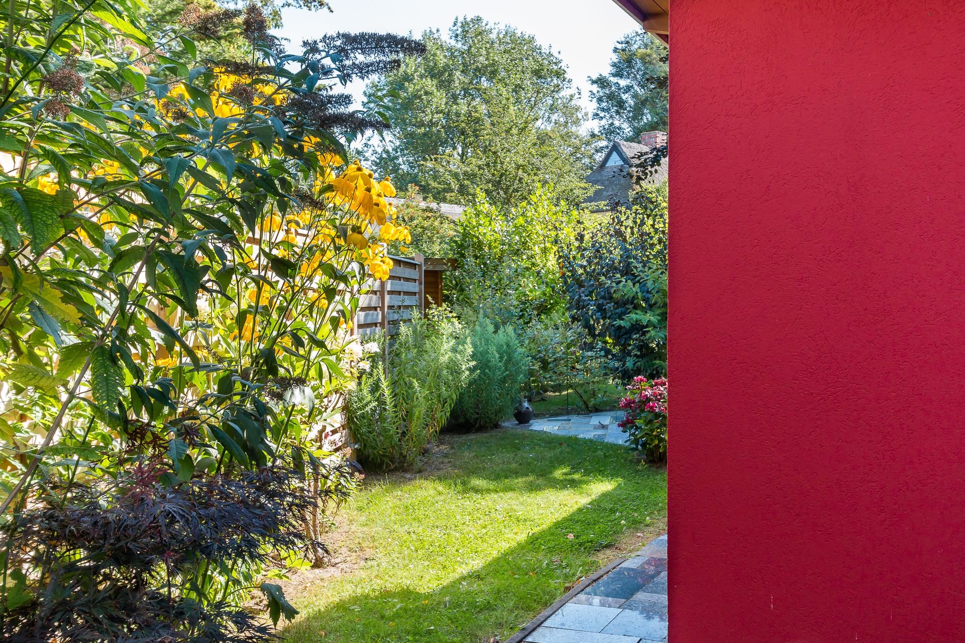 Gartenansicht mit bunten Pflanzen und Gehweg