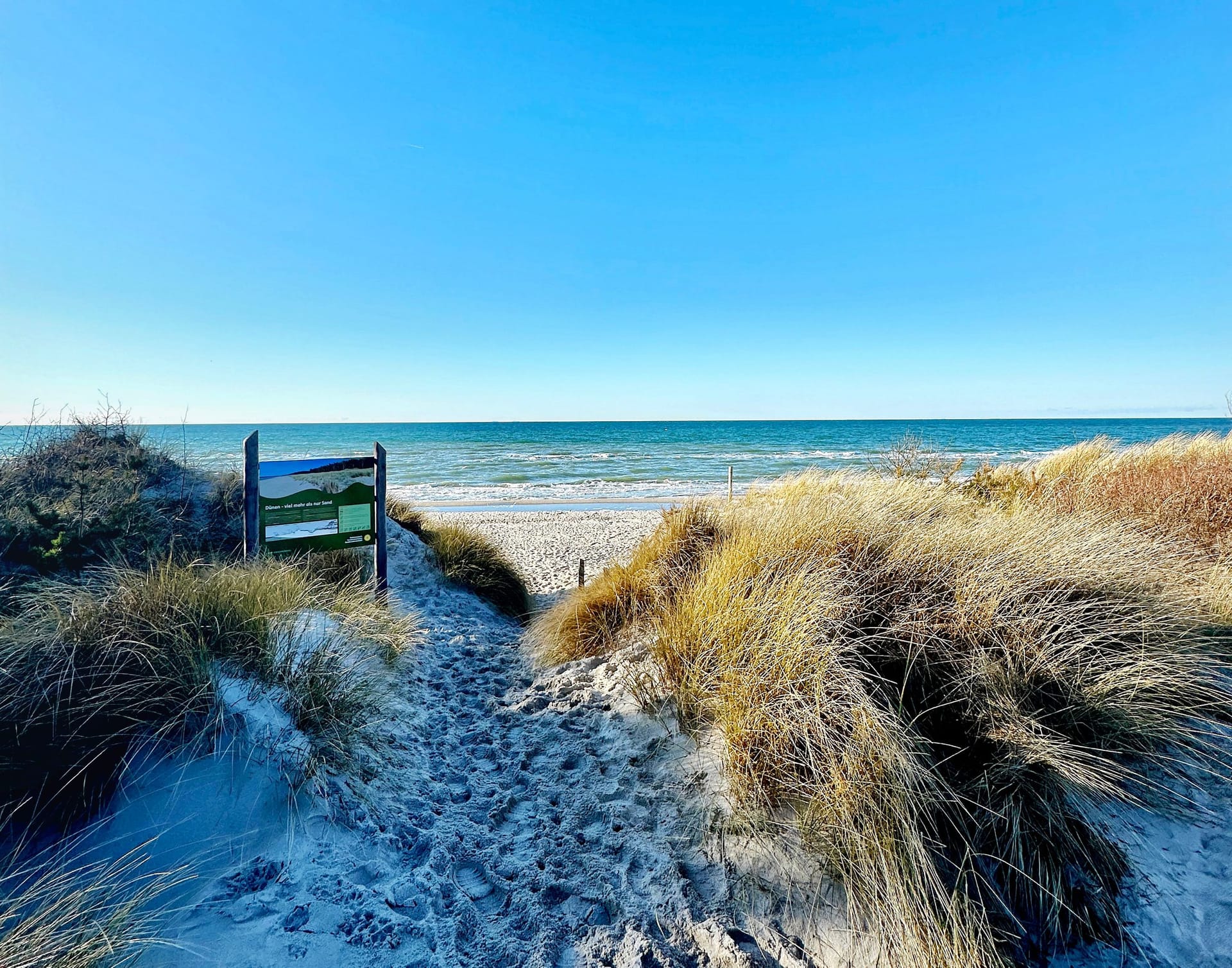 Zugang zum Strand mit Düne und klarem Himmel