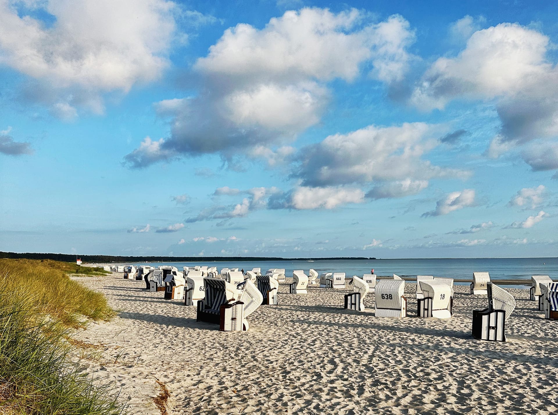 Strand mit Strandkörben und blauem Himmel