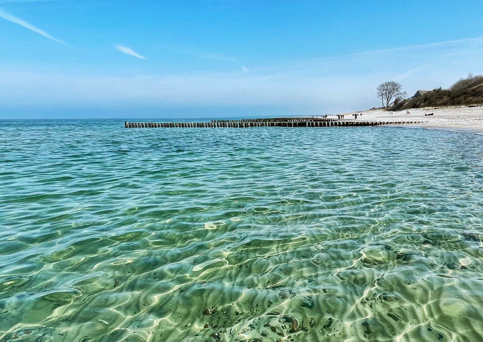 Küstenansicht mit klarem Wasser und Holzsteg