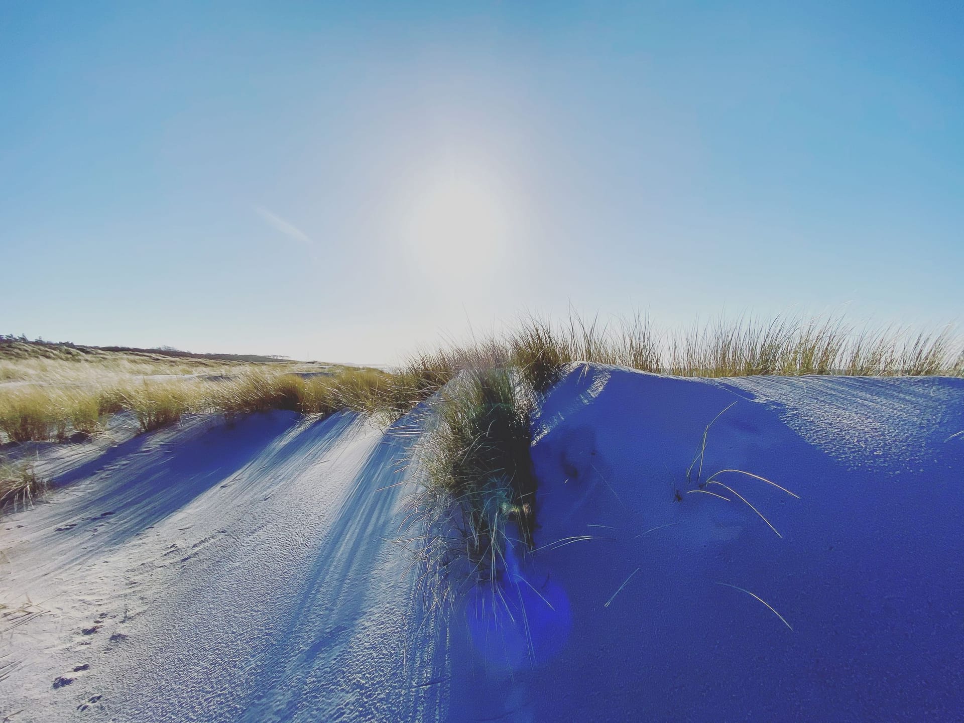 Strand mit hohen Dünen und Sonnenschein