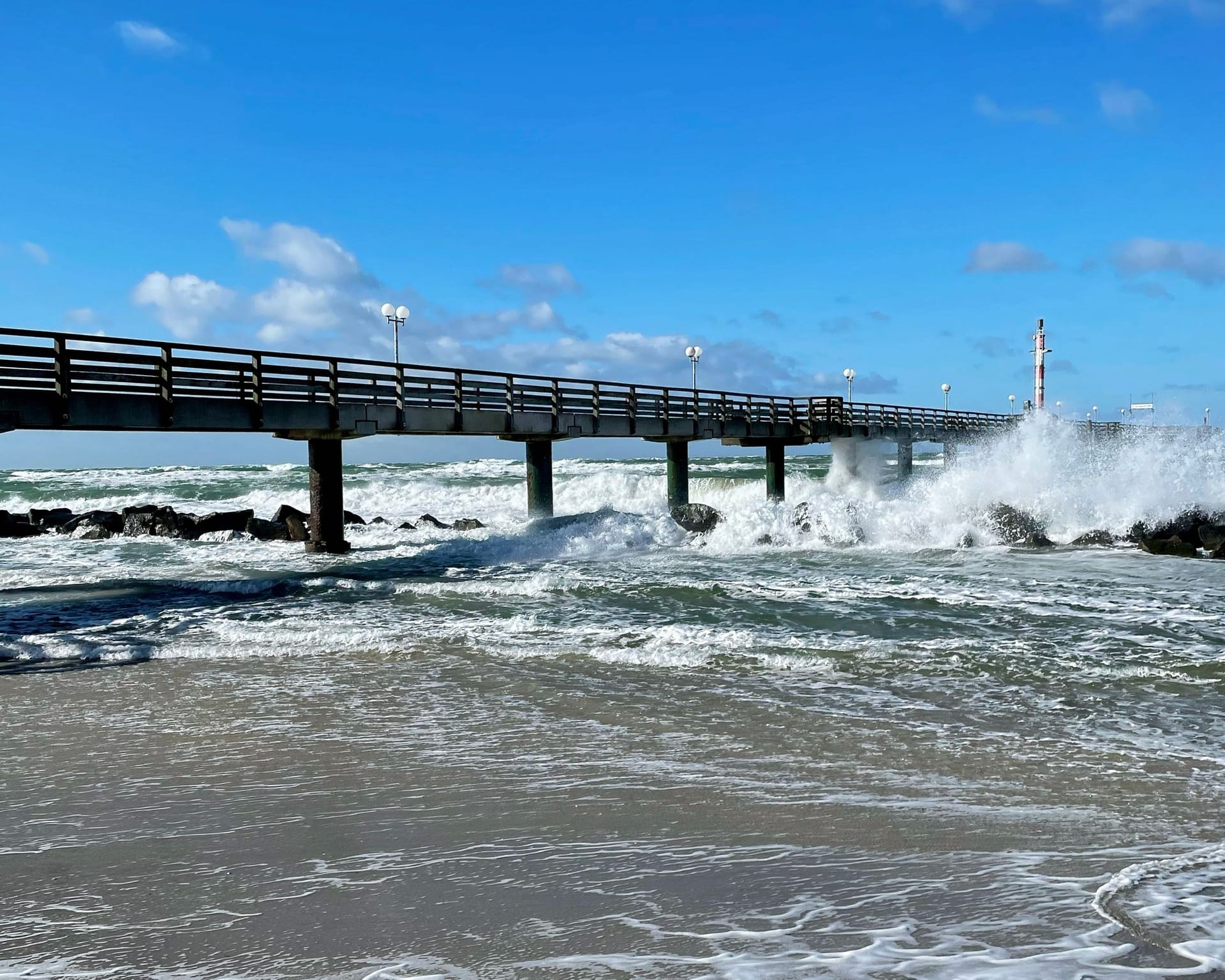 Seebrücke mit Wellen am Strand