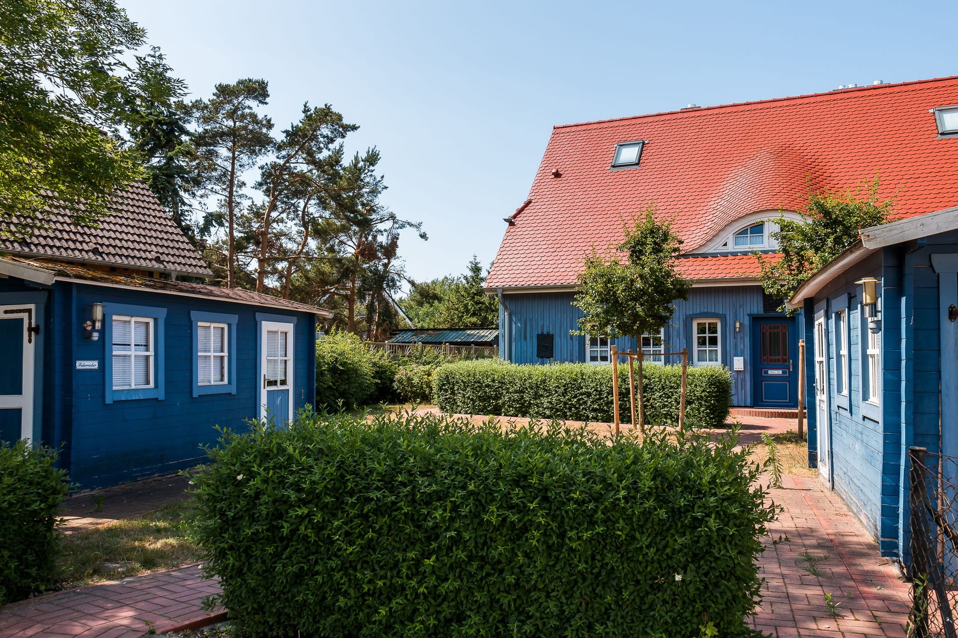 Außenansicht eines blauen Ferienhauses mit roten Dächern