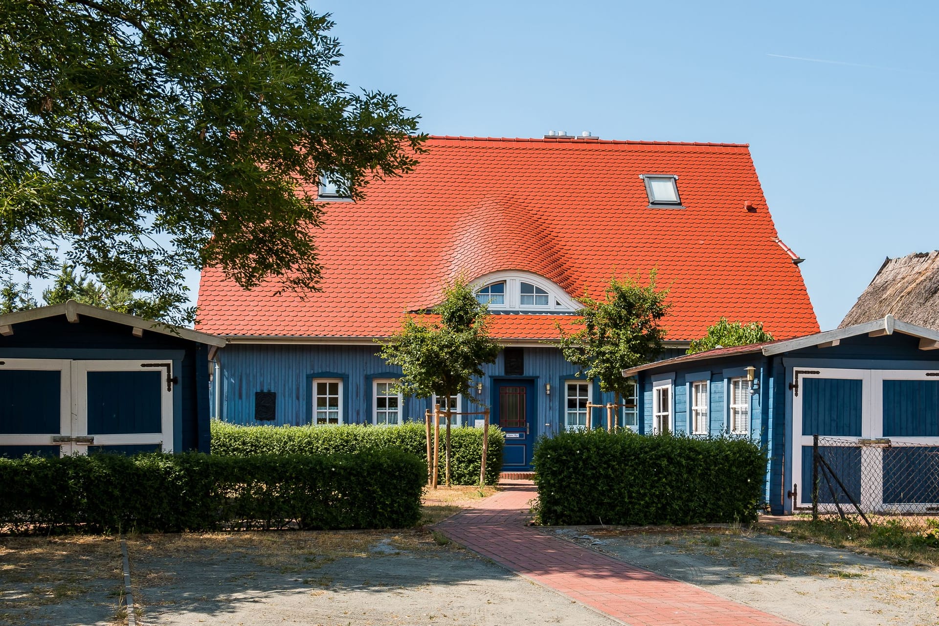 Außenansicht eines blauen Hauses mit rotem Dach