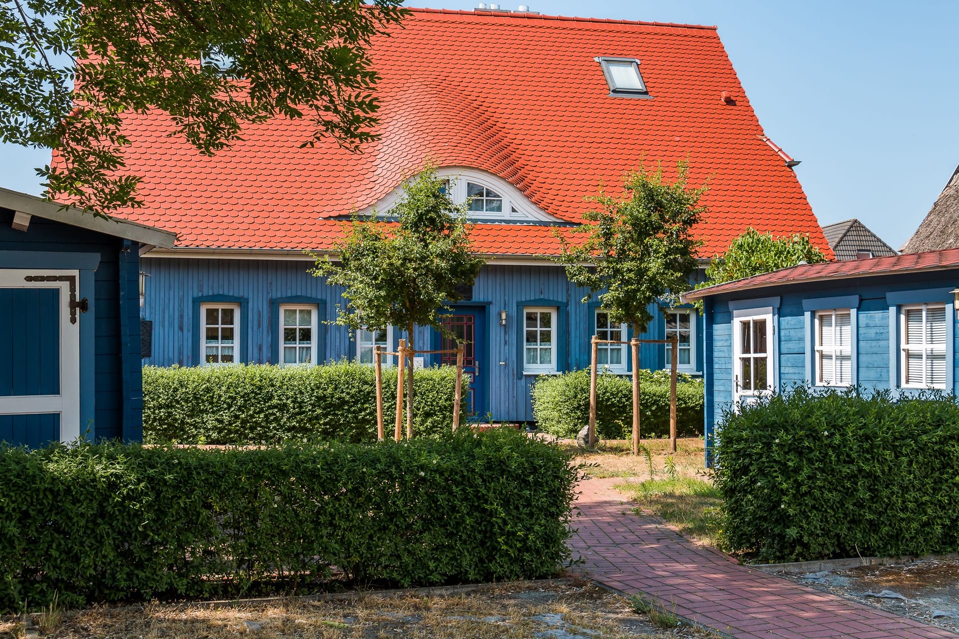 Außenansicht eines blauen Hauses mit rotem Dach