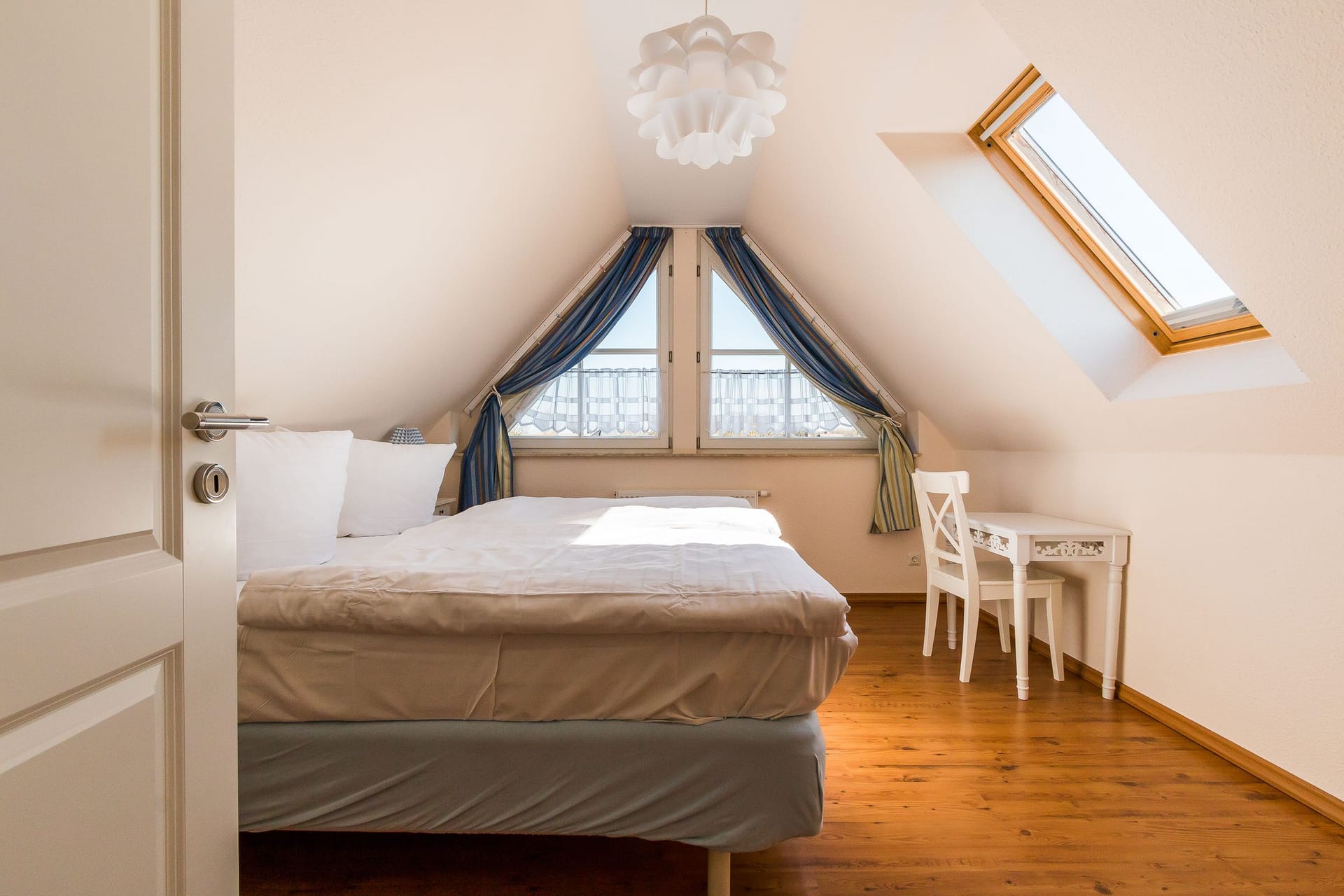 Helles Schlafzimmer mit Tisch und Dachfenstern
