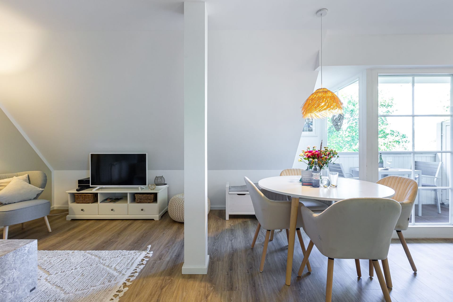 Heller Wohnbereich mit Fernseher und Esstisch