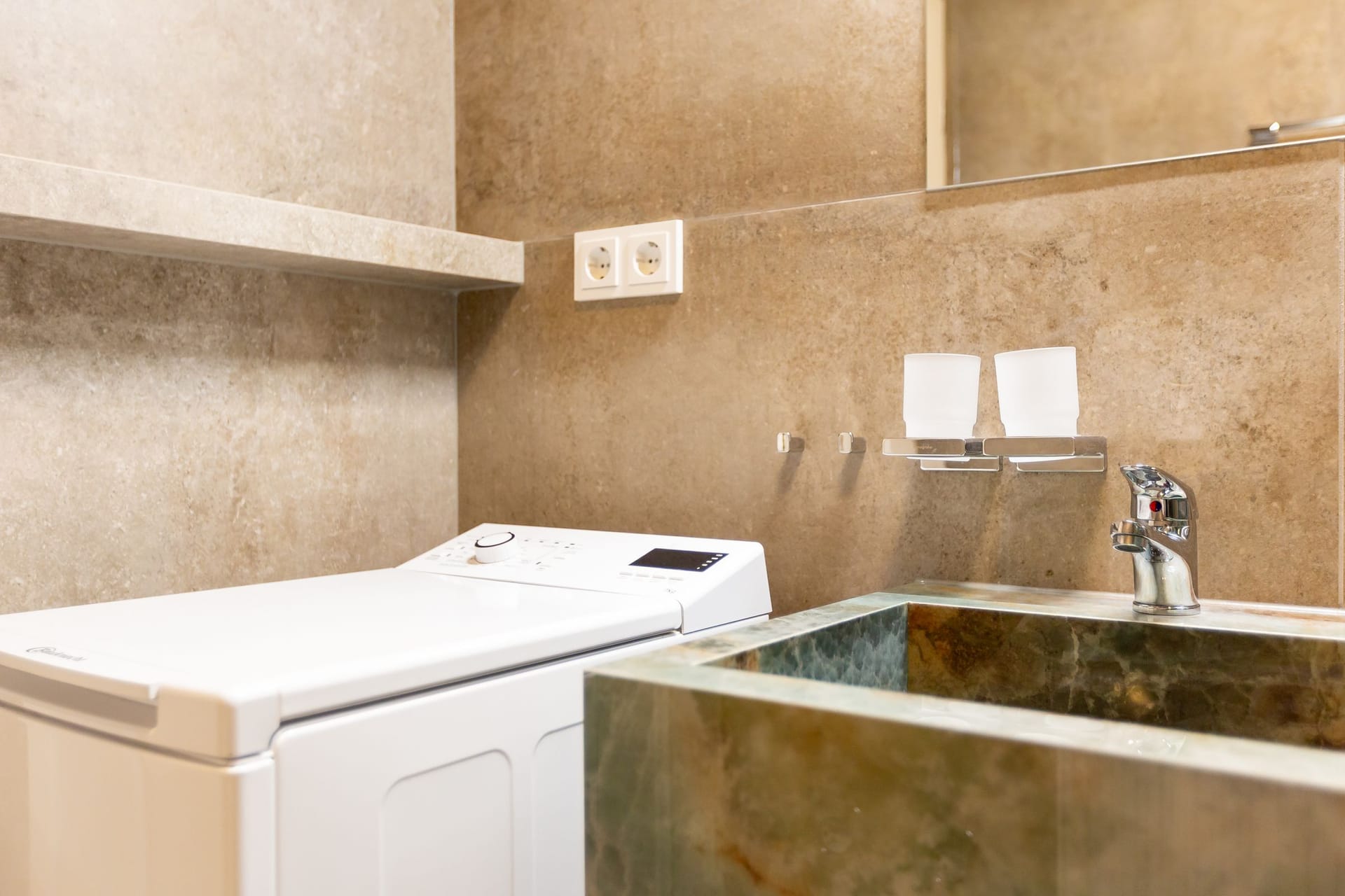 Badezimmer mit Waschmaschine und Waschbecken