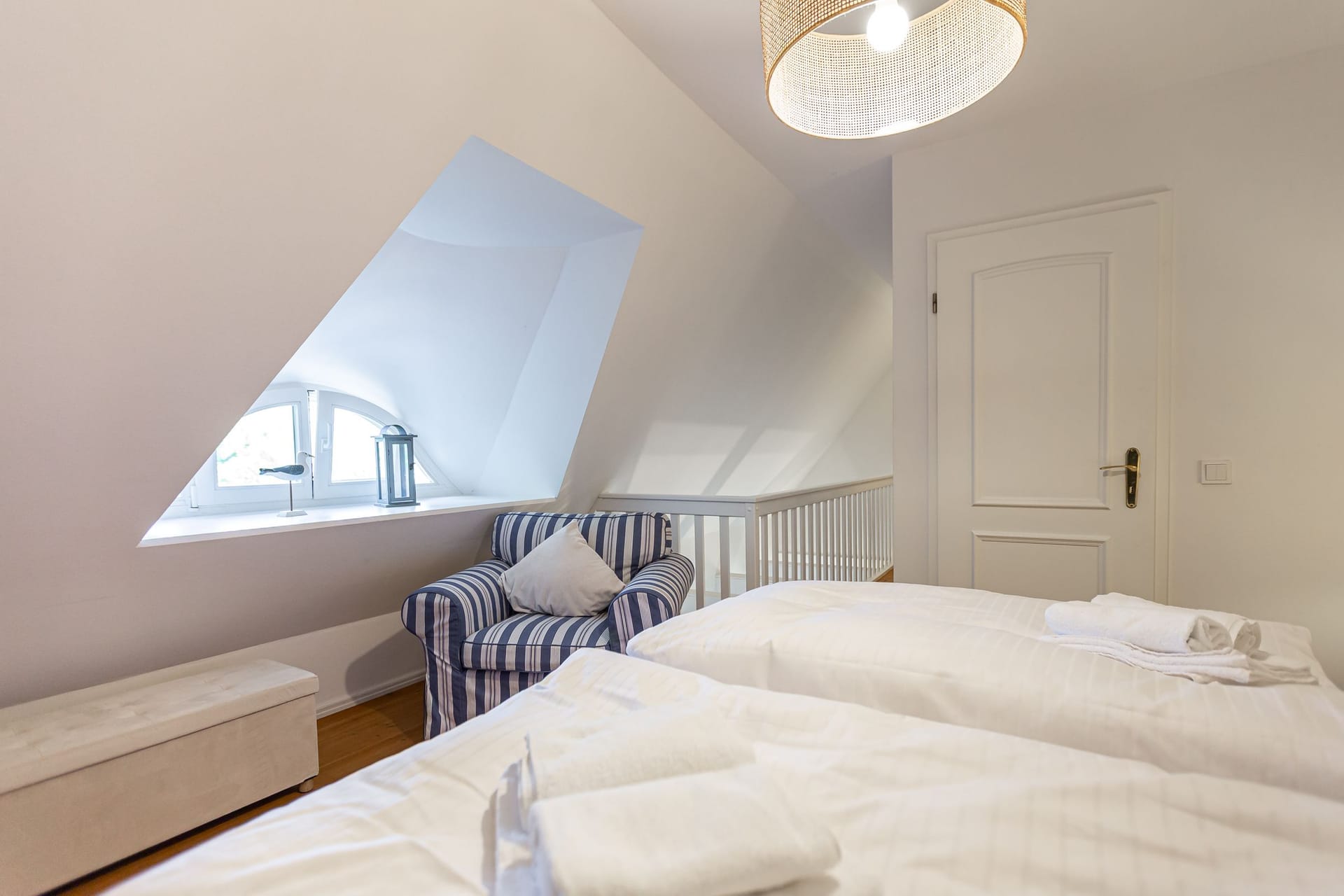 Schlafzimmer mit zwei Betten und Sessel