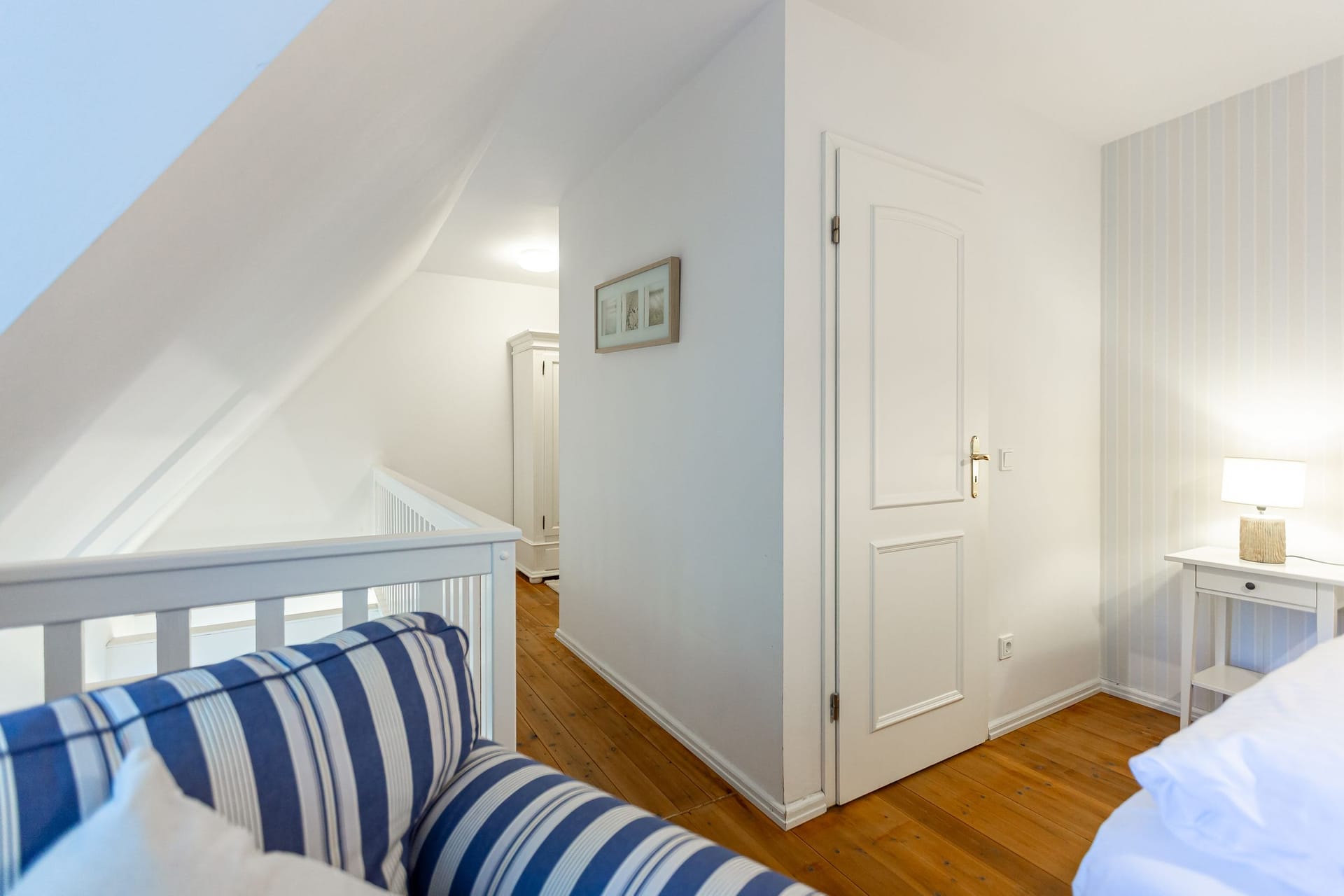 Schlafzimmer mit blauem Sofa und hellem Tisch