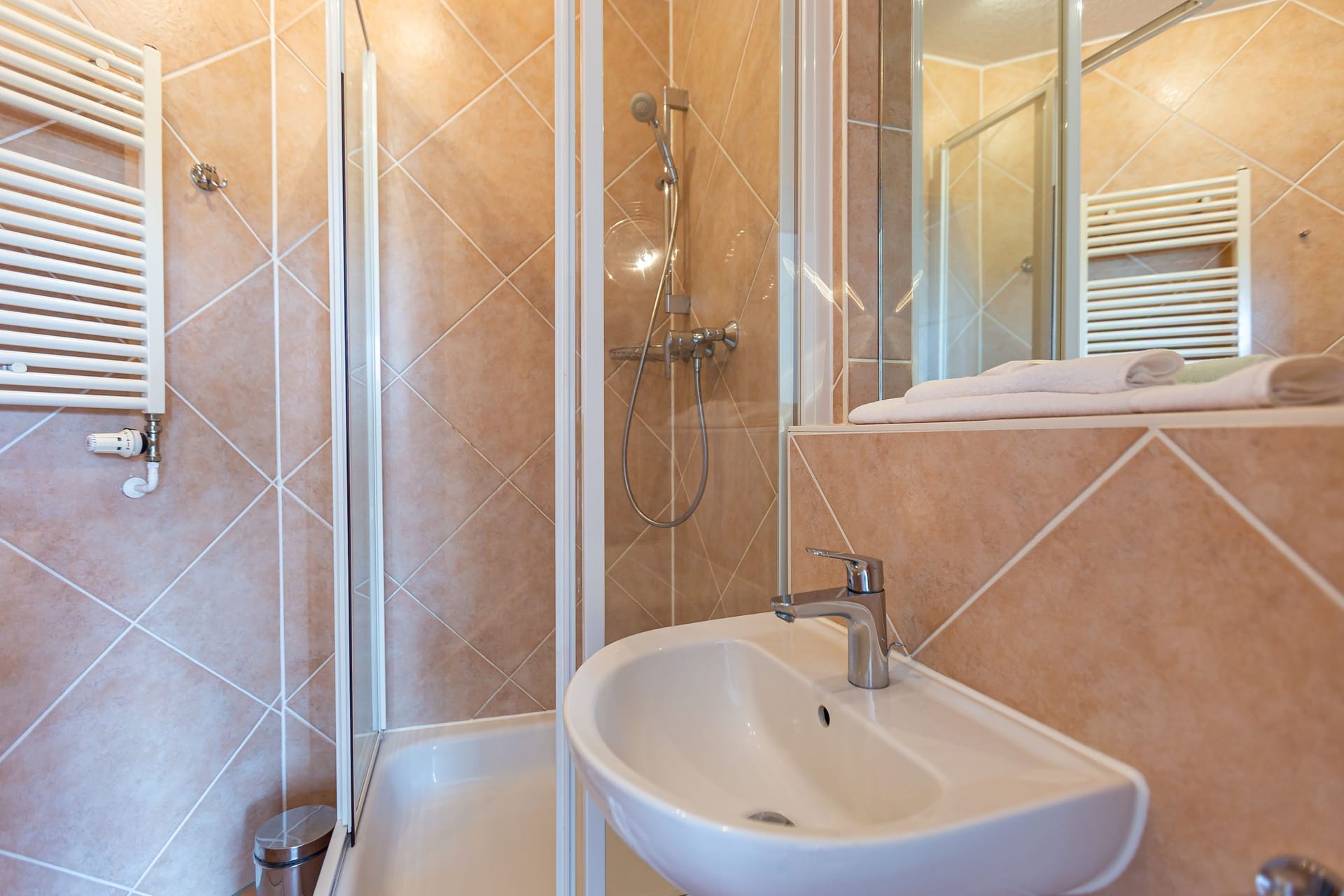 Badezimmer mit Dusche und modernem Waschbecken