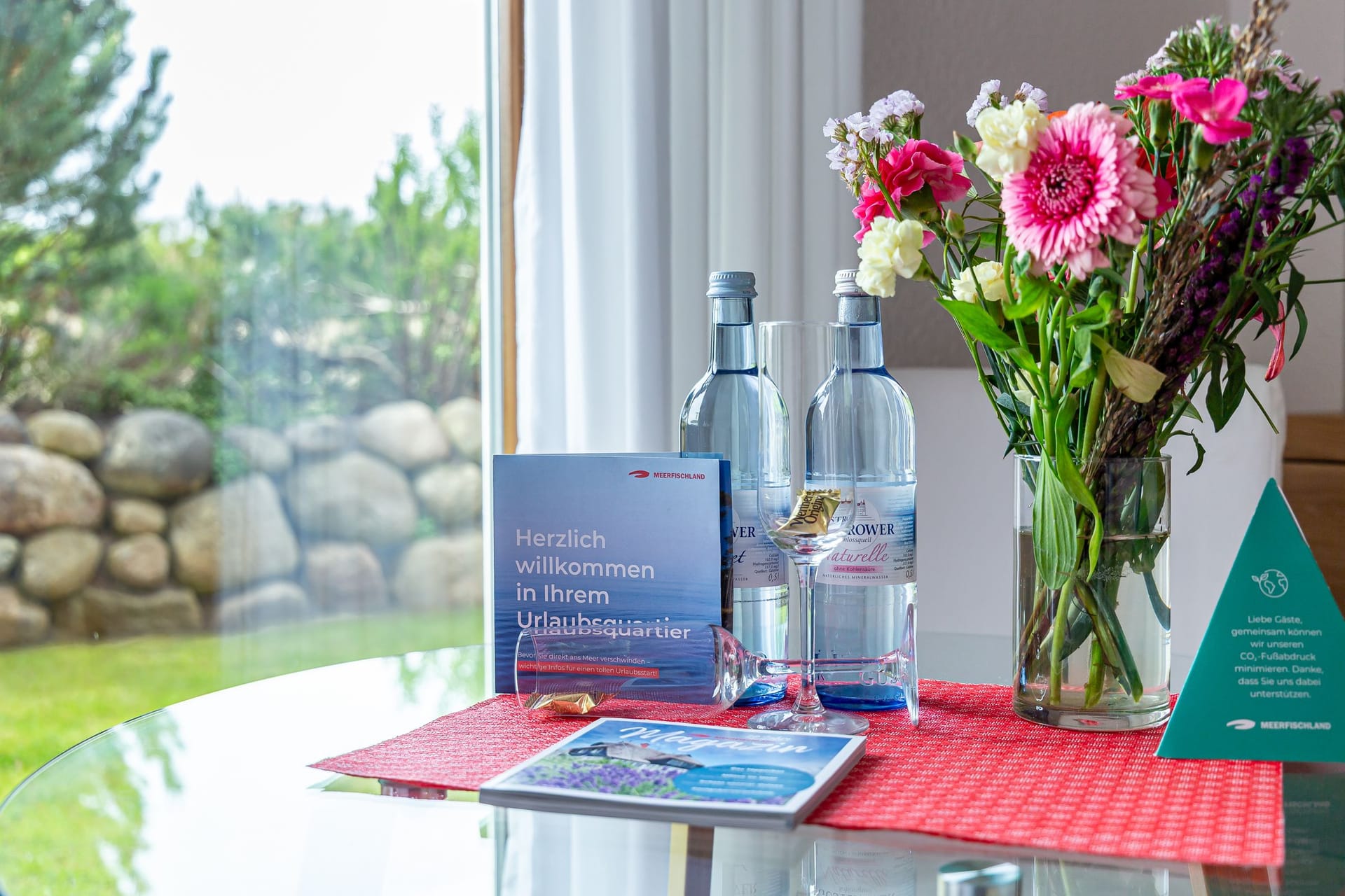Wohnzimmer mit Tisch, Wasserflaschen und Blumen