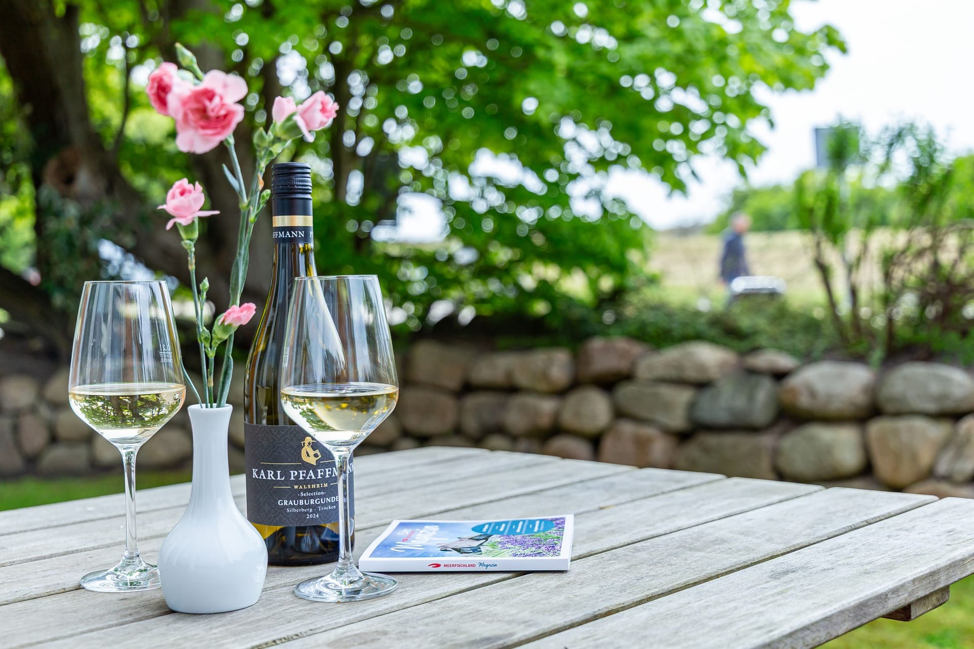 Terrasse mit Weingläsern und Blumen