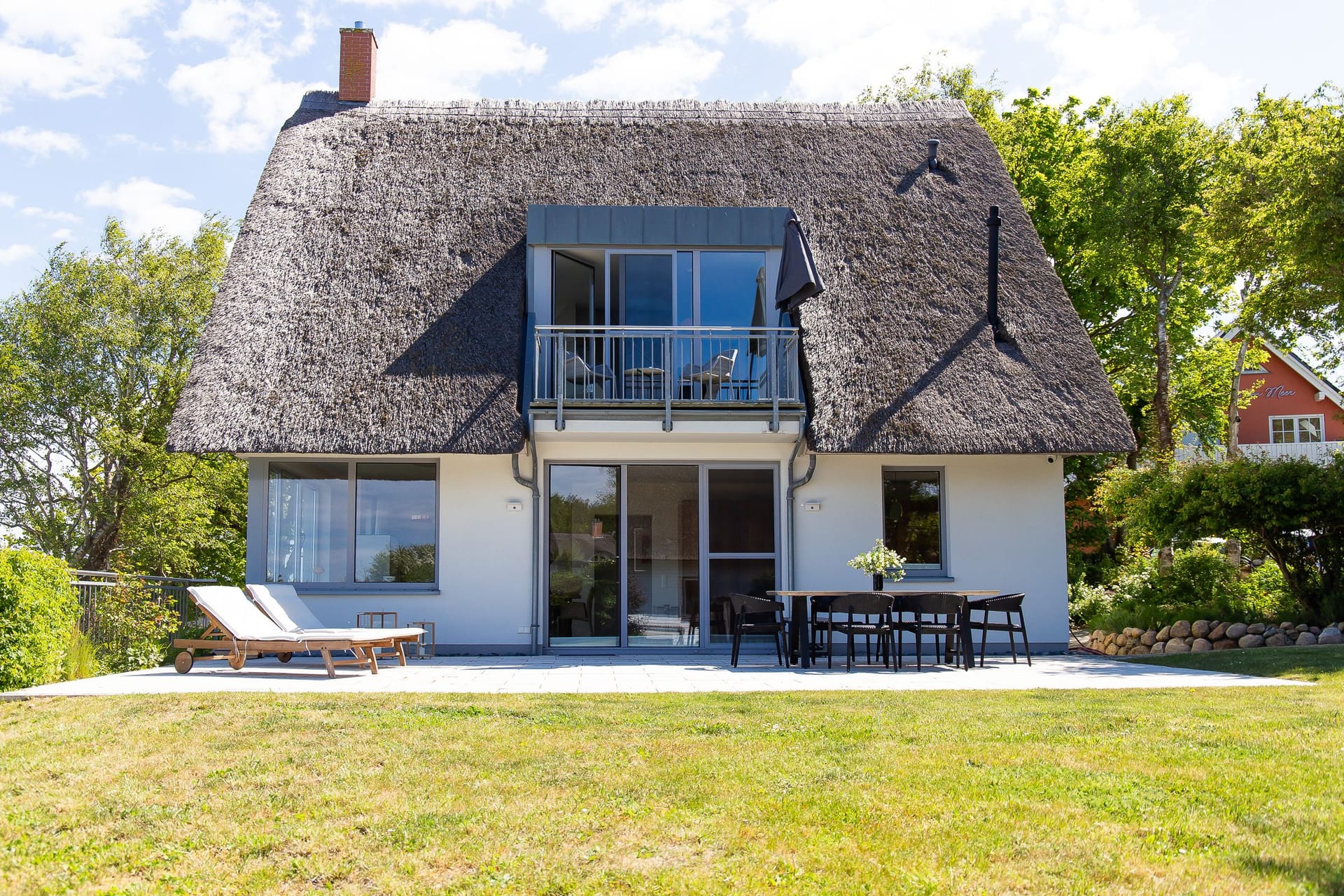 Außenansicht eines Reetdachhauses mit Balkon