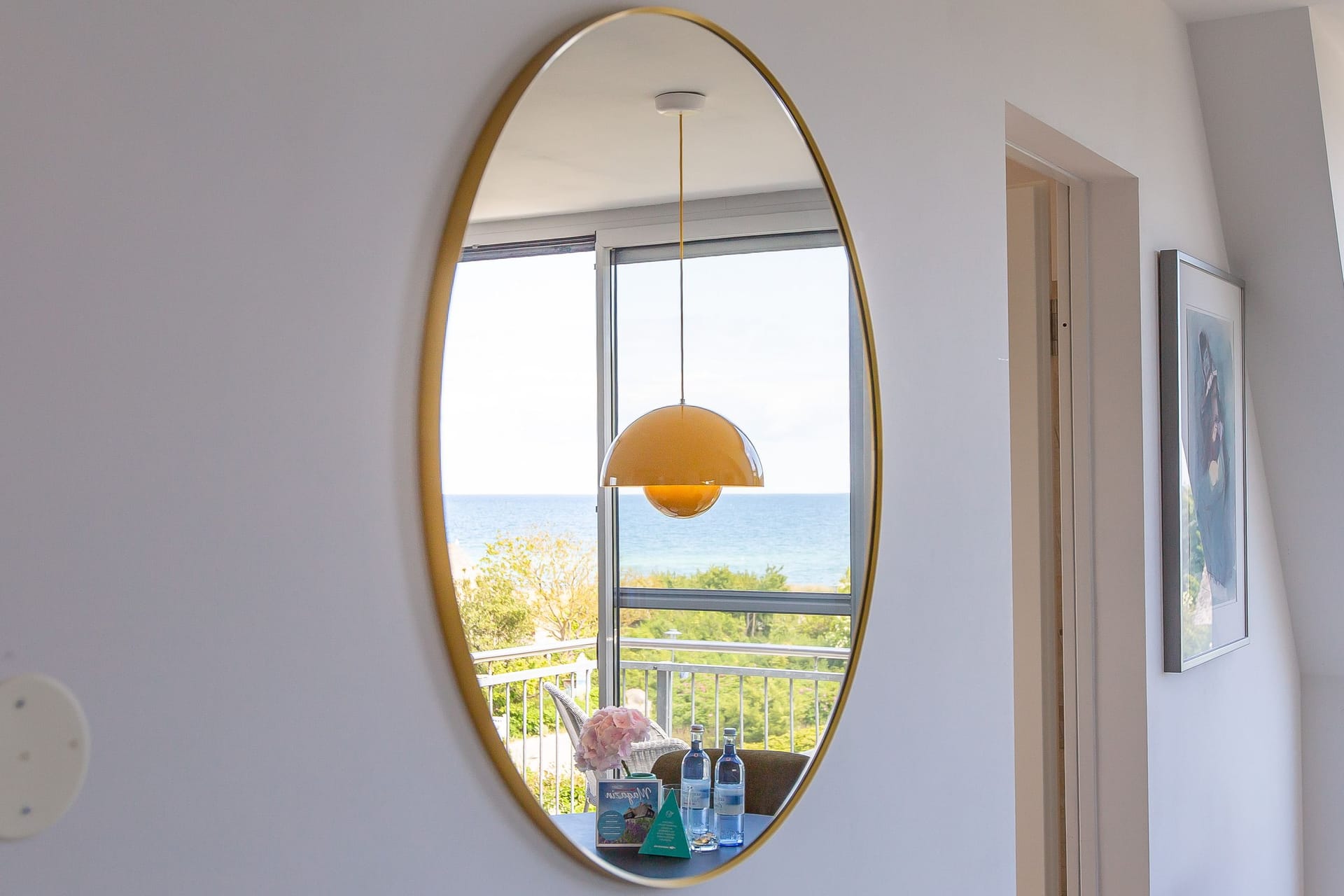 Heller Wohnraum mit Meerblick und Ovalspiegel