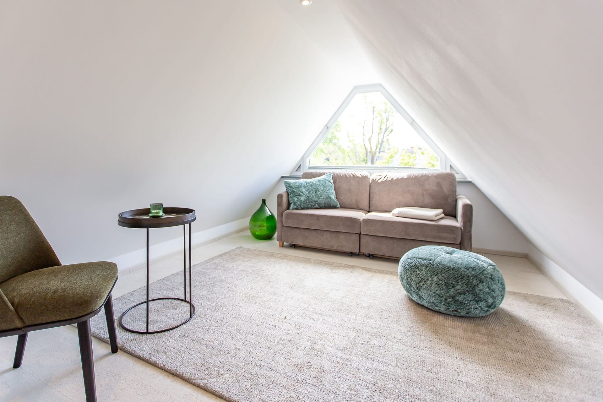 Wohnzimmer mit Sofa und Blick ins Grüne