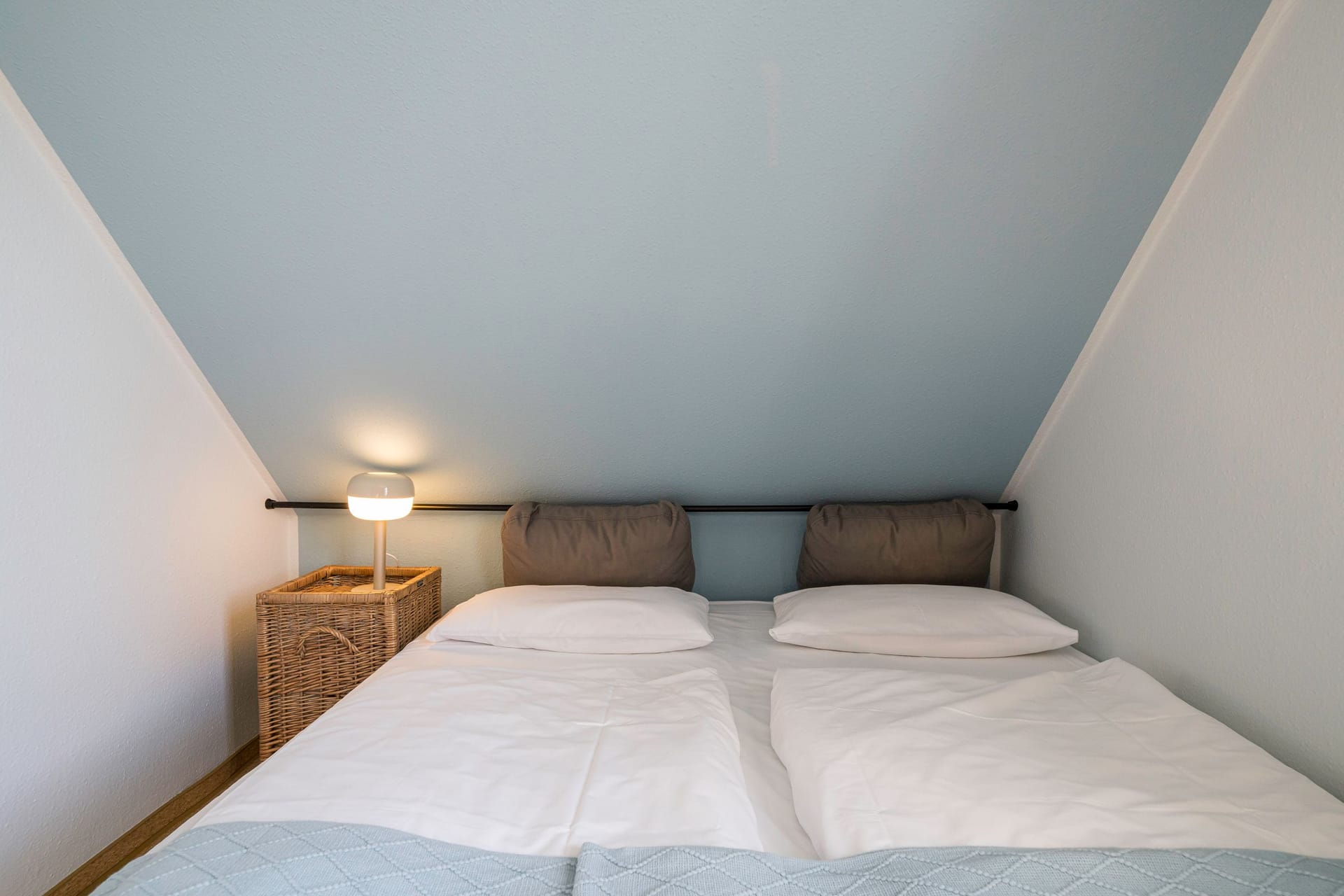 Schlafzimmer mit Doppelbett und Nachttischlampe