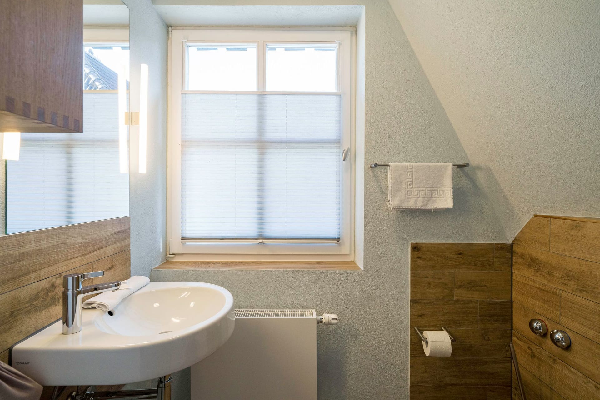 Helles Badezimmer mit Waschbecken und Fenster