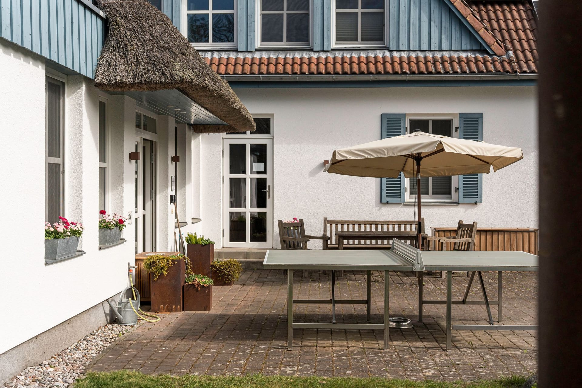 Terrasse mit Tisch und Sonnenschirm