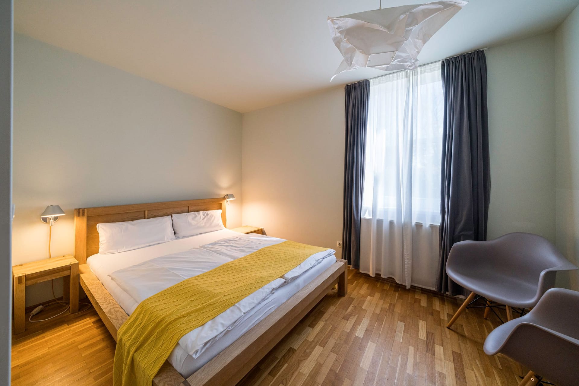 Helles Schlafzimmer mit Doppelbett und Sitzgelegenheit