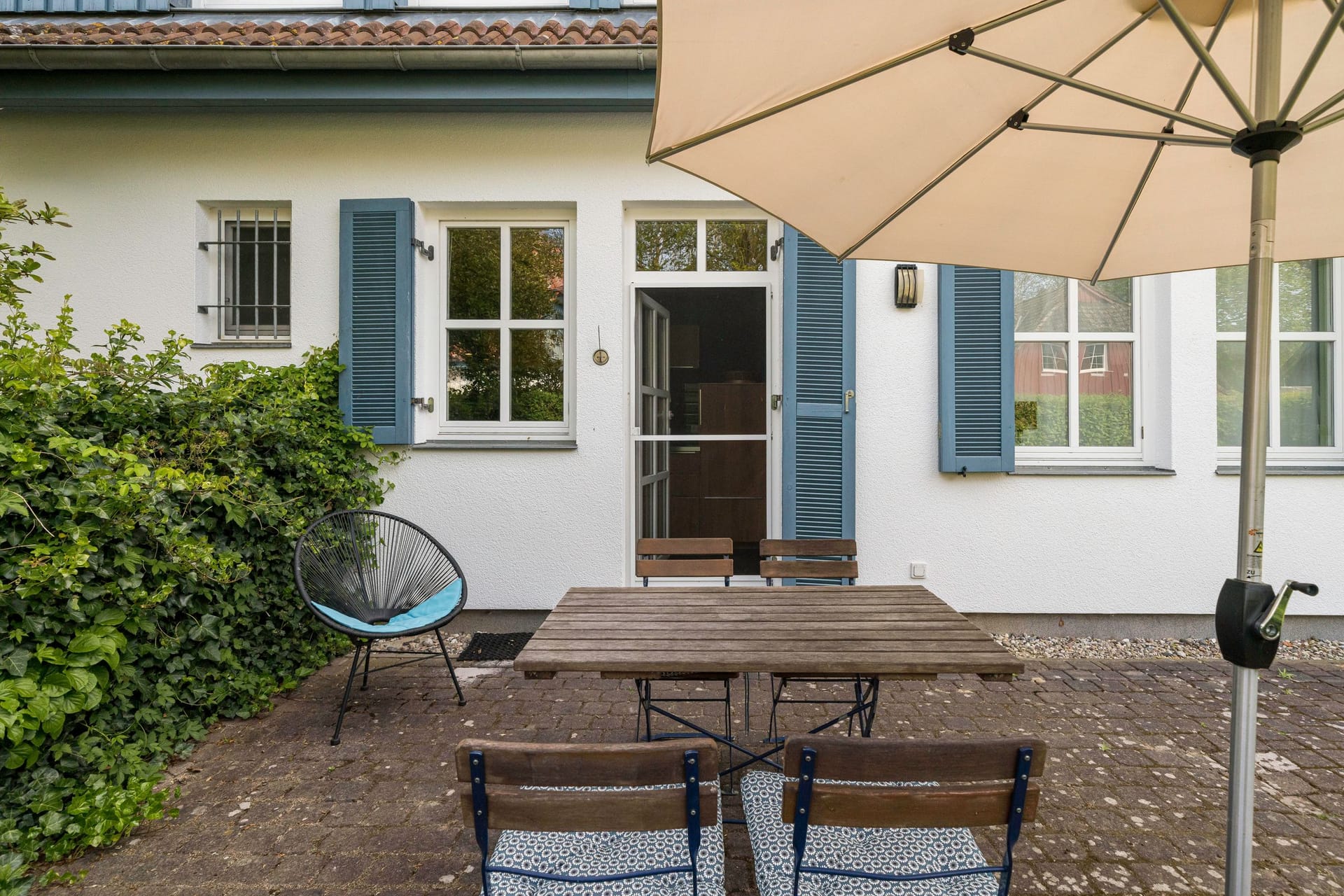 Terrasse mit Tisch und Sonnenschirm
