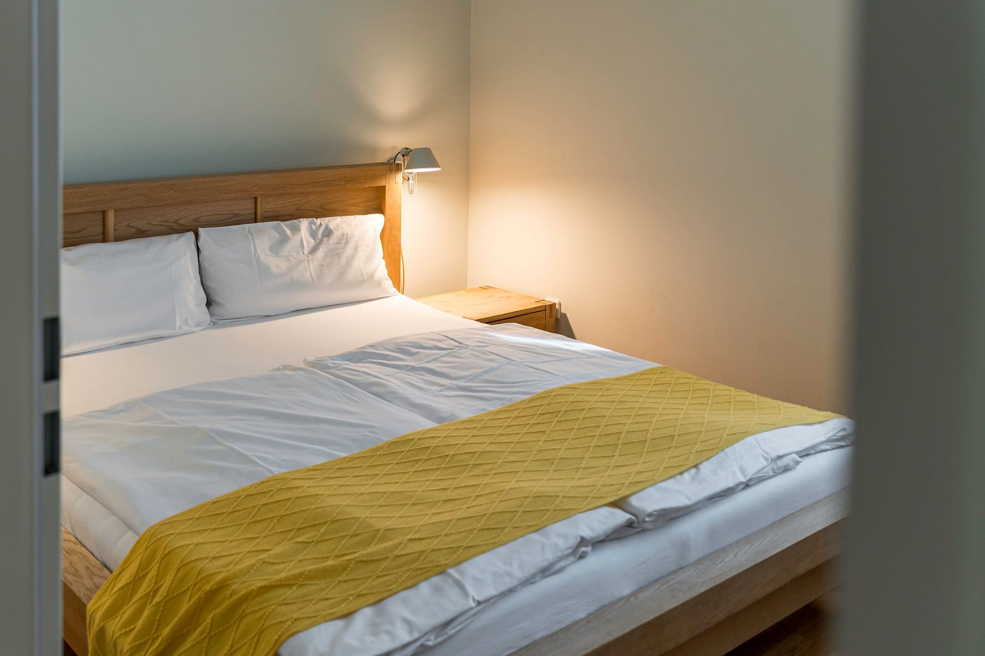 Schlafzimmer mit Doppelbett und gelber Bettdecke