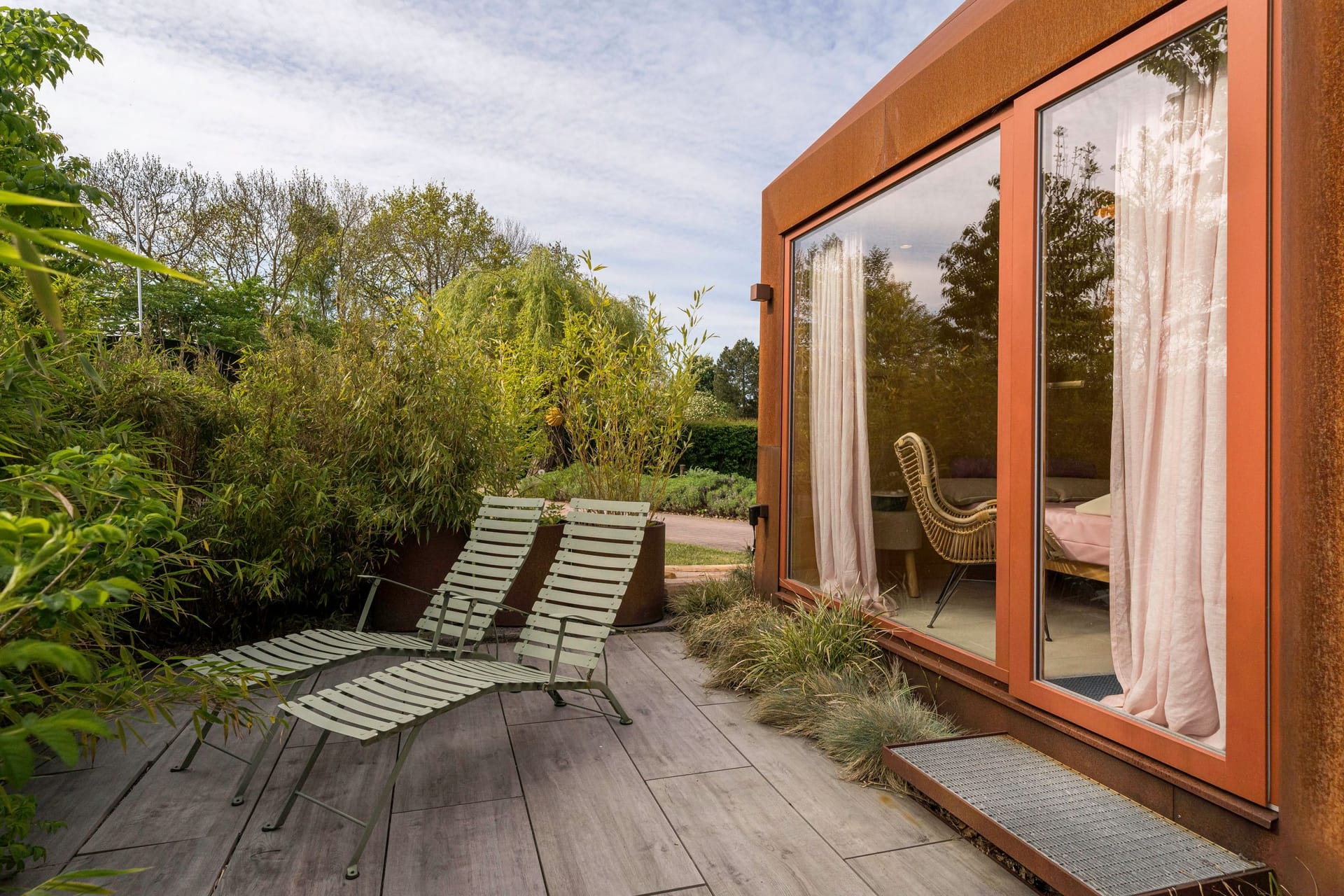 Terrasse mit Liegestühlen und Blick auf den Garten