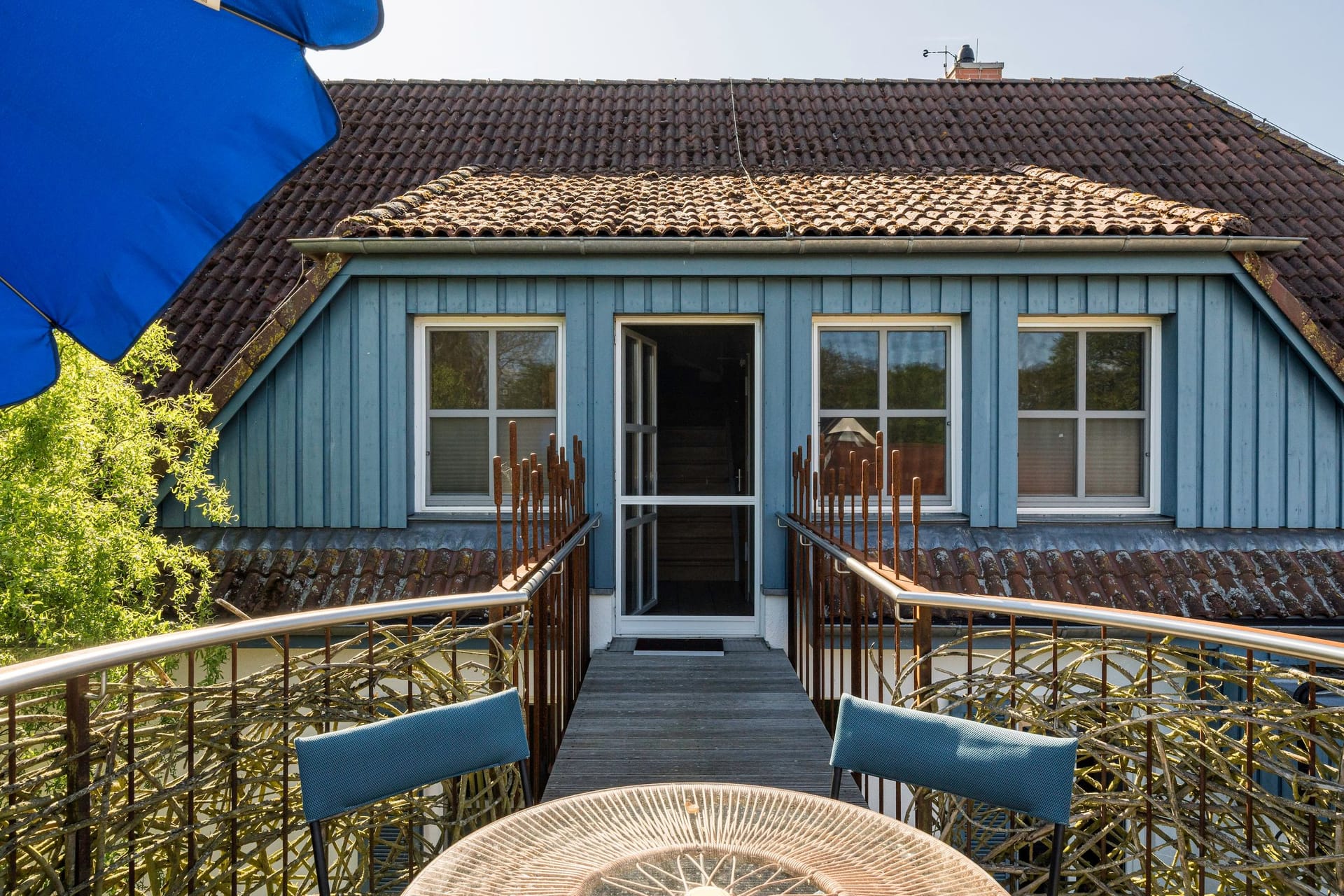 Terrasse mit Tisch und blauen Stühlen