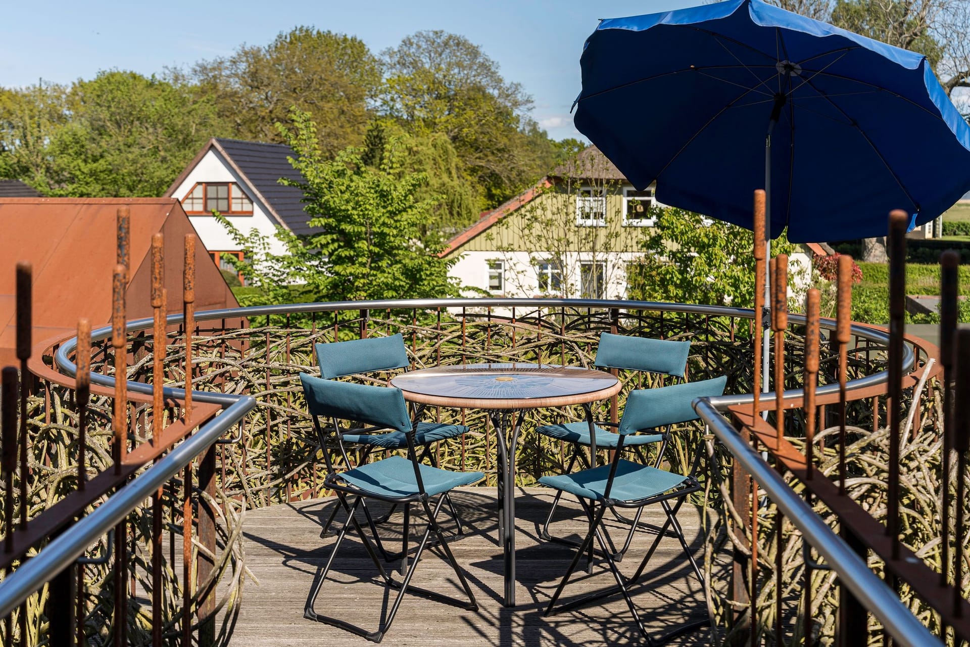 Terrasse mit Tisch und Stühlen unter Sonnenschirm