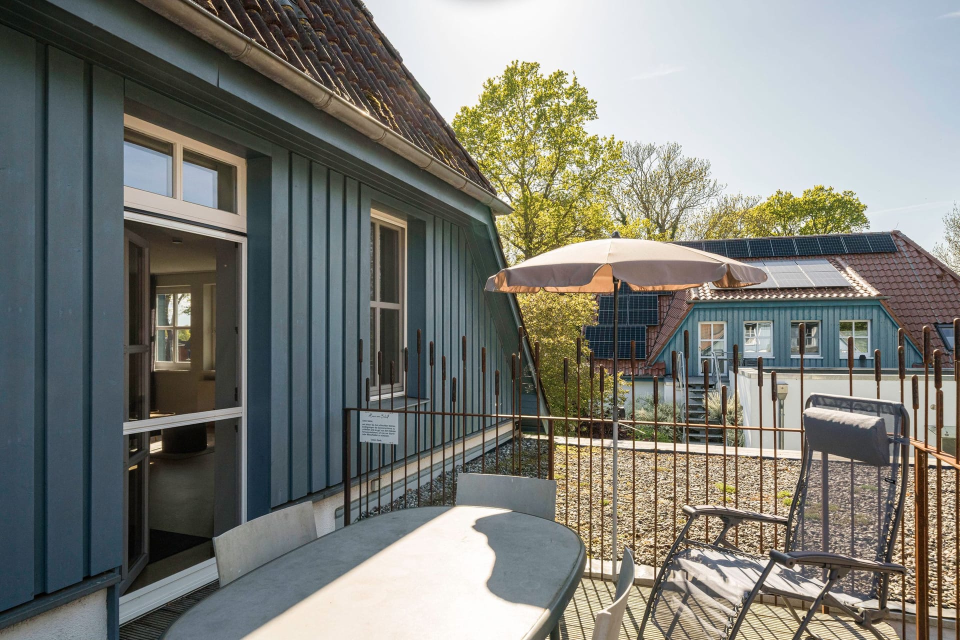 Terrasse mit Sonnenschirm und Liegestuhl