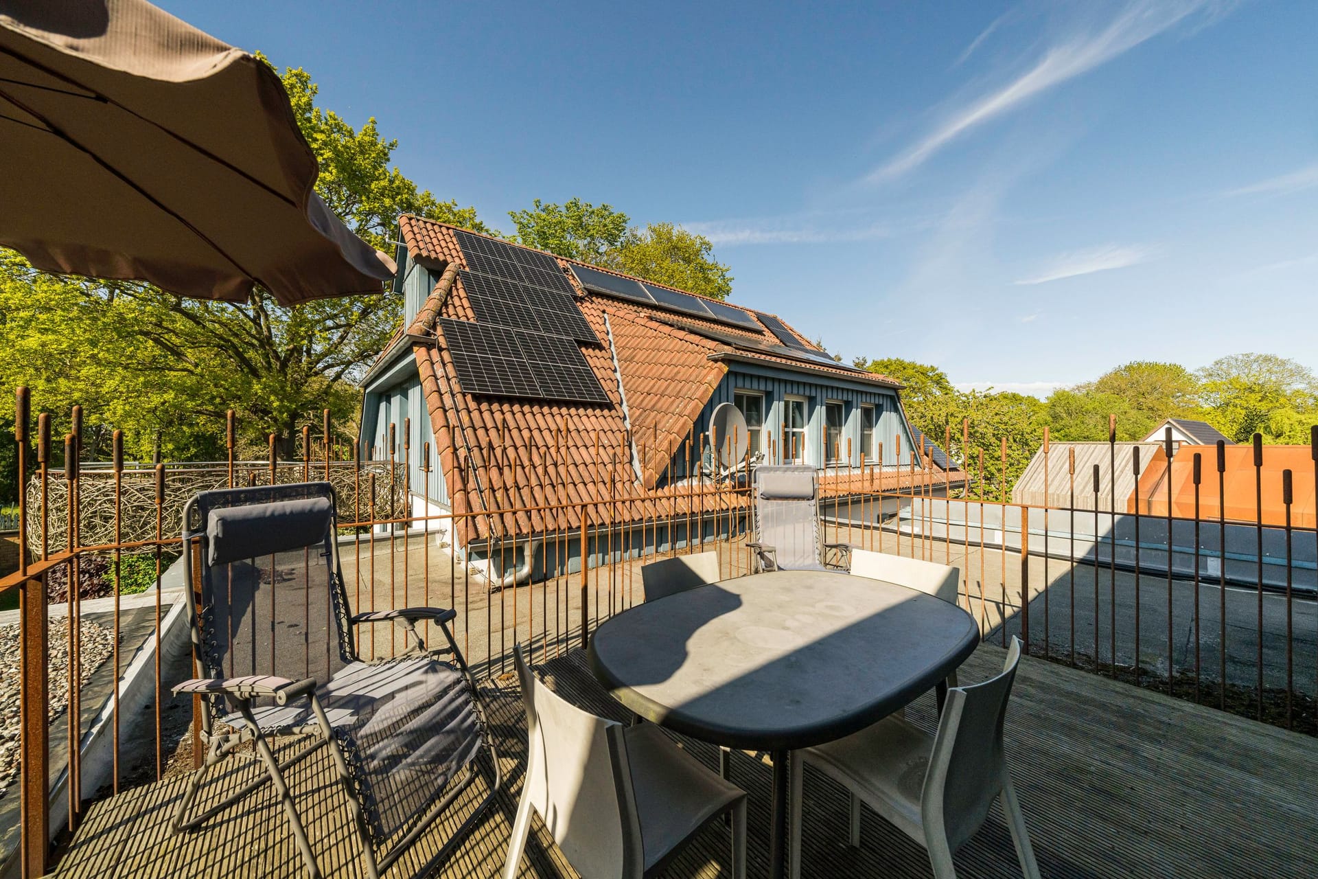 Terrasse mit Tisch und Sonnenschirm