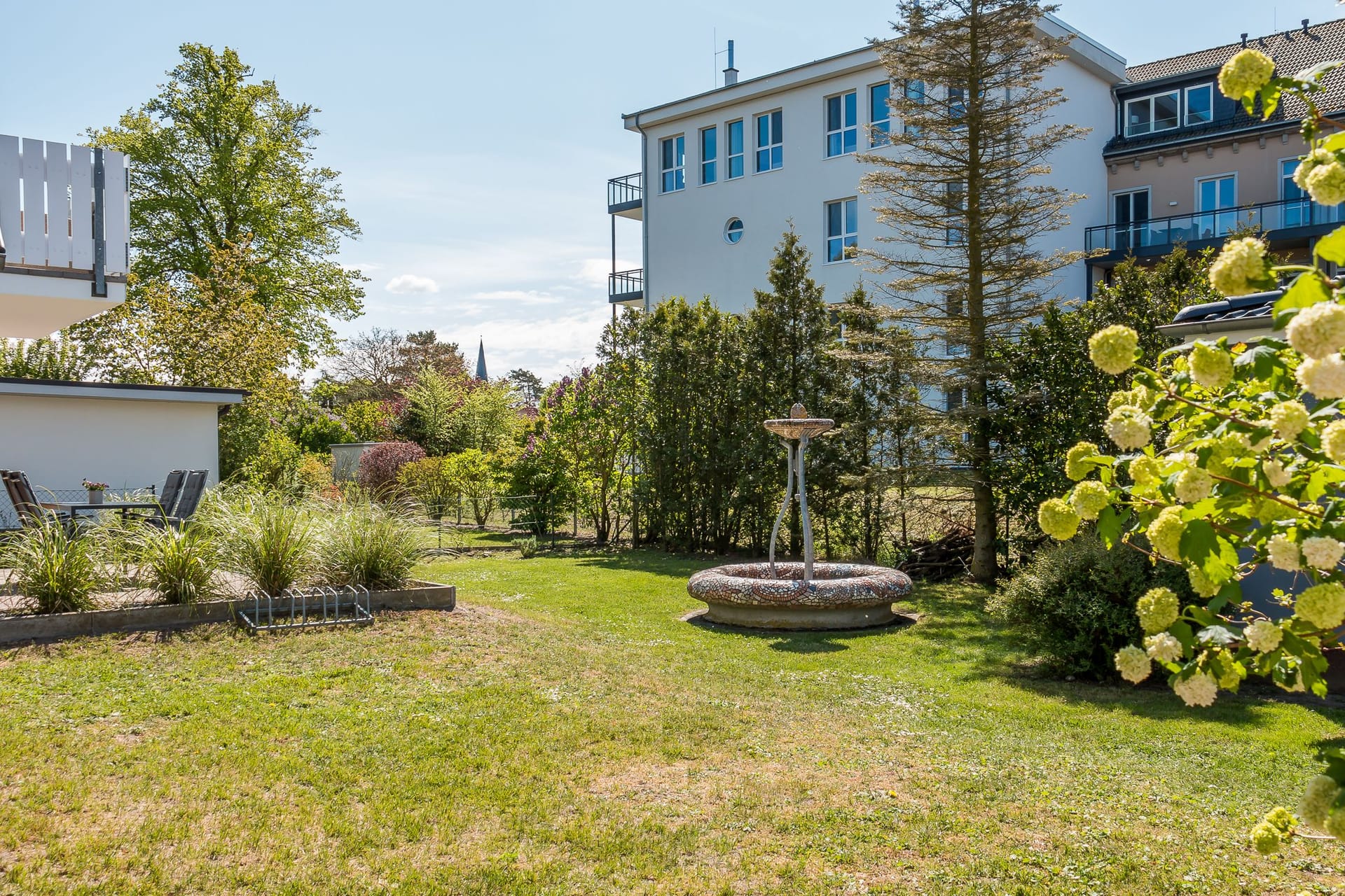 Gartenansicht mit Fontäne und Bäumen