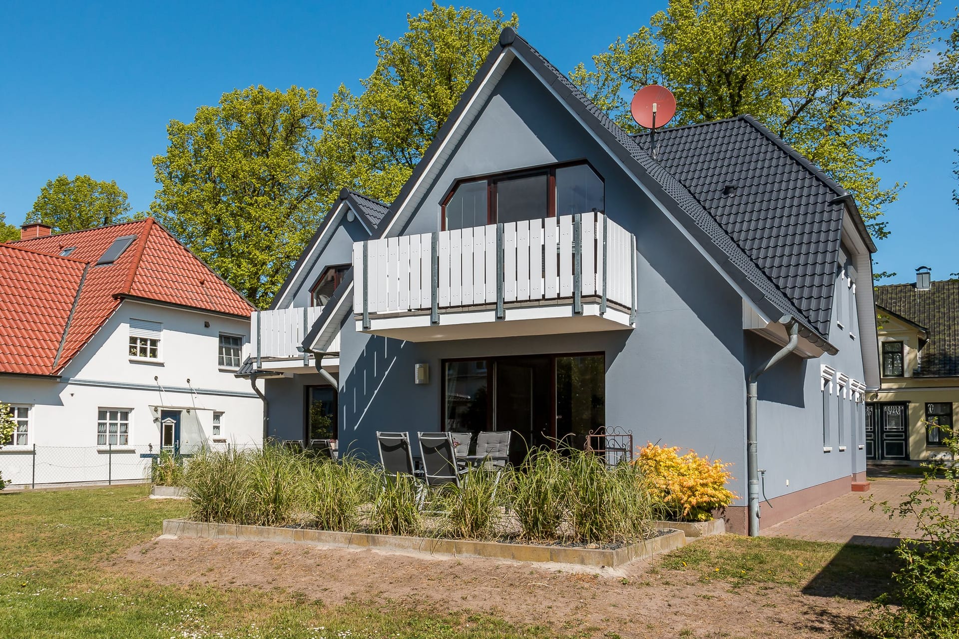 Außenansicht eines Hauses mit Balkon und Garten