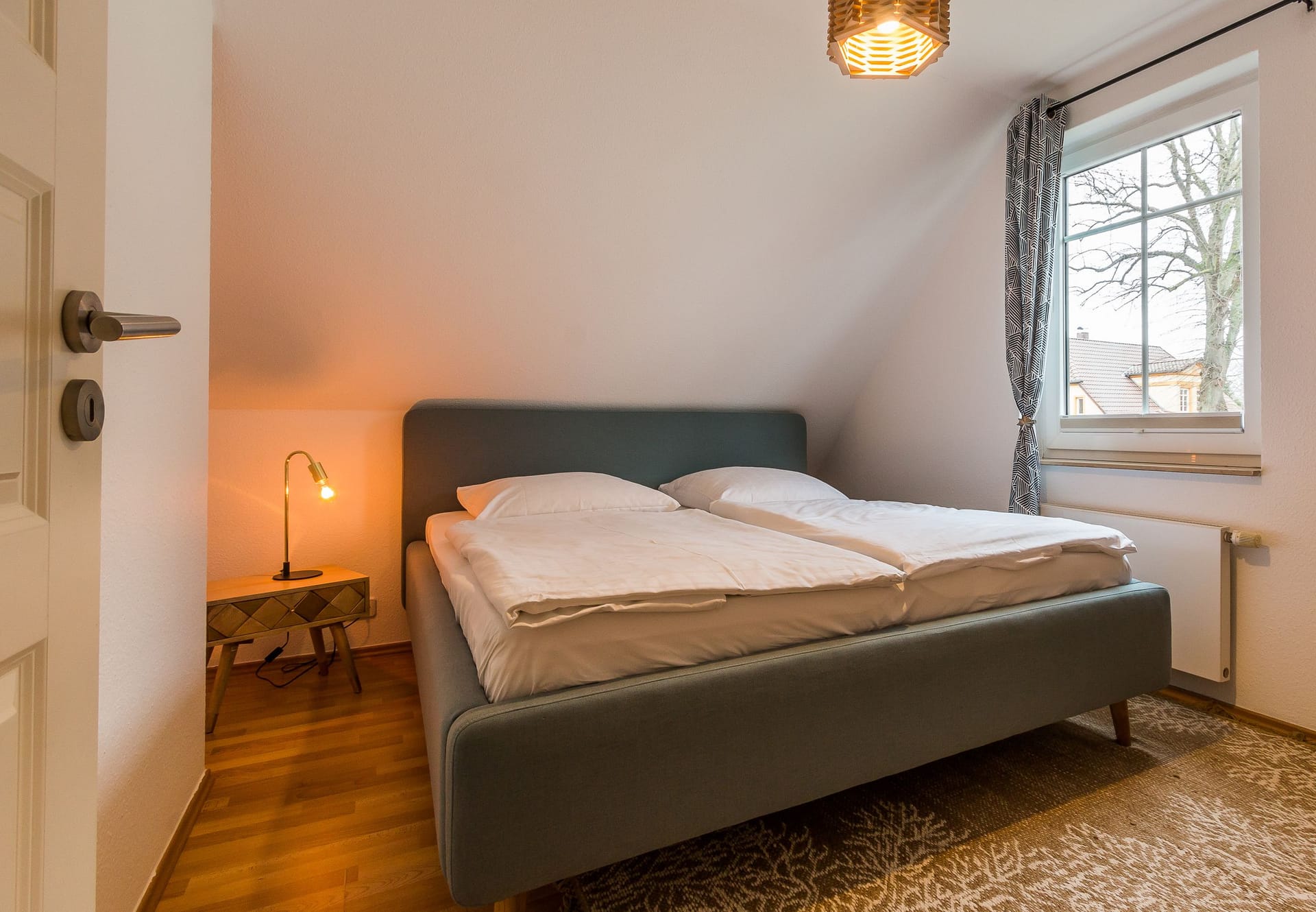 Schlafzimmer mit modernem Doppelbett und Nachttischlampe