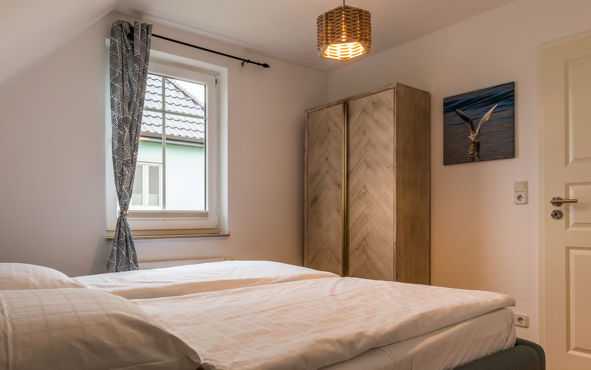 Helles Schlafzimmer mit Doppelbett und Fenster