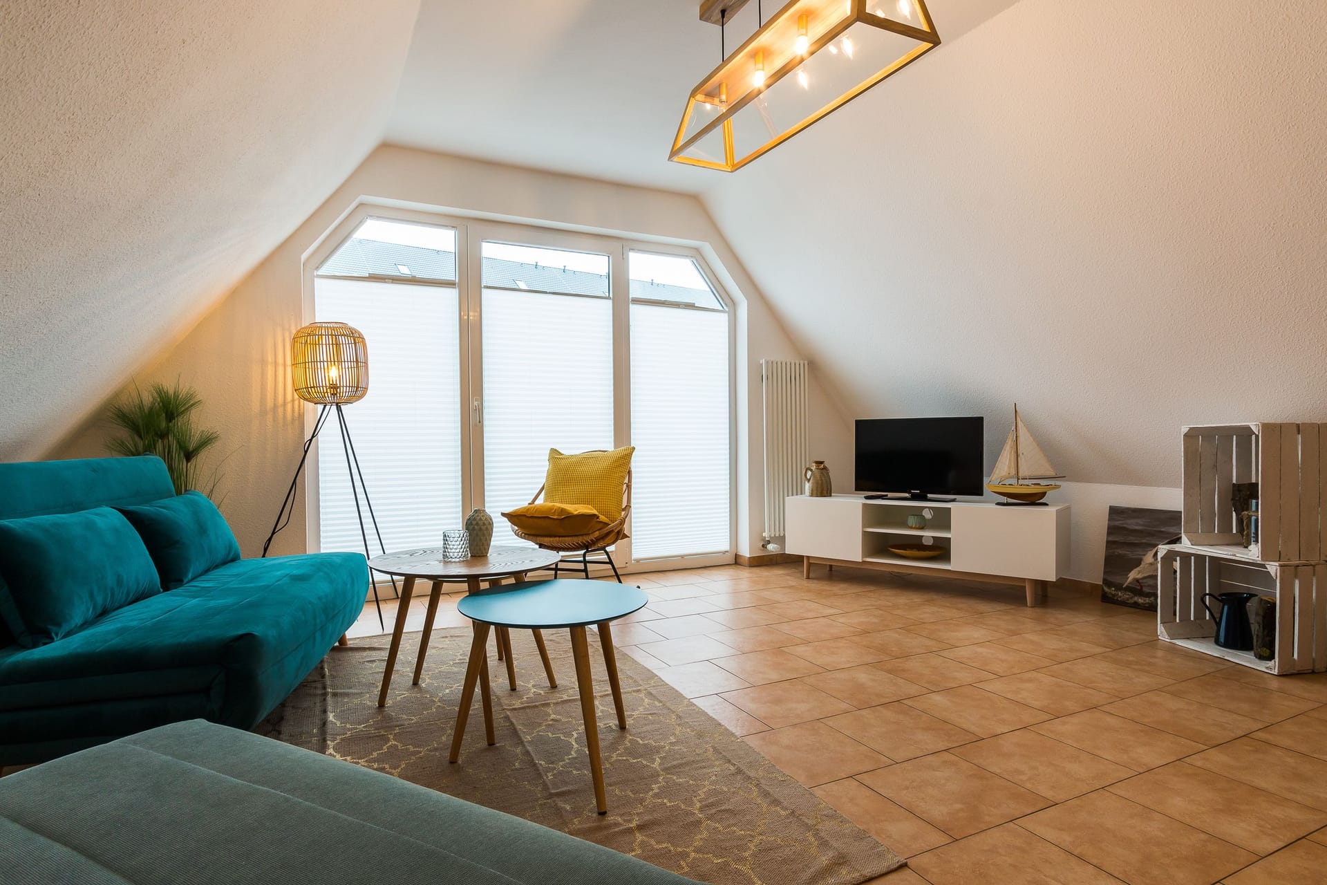 Heller Wohnbereich mit Sofa und Fernseher.