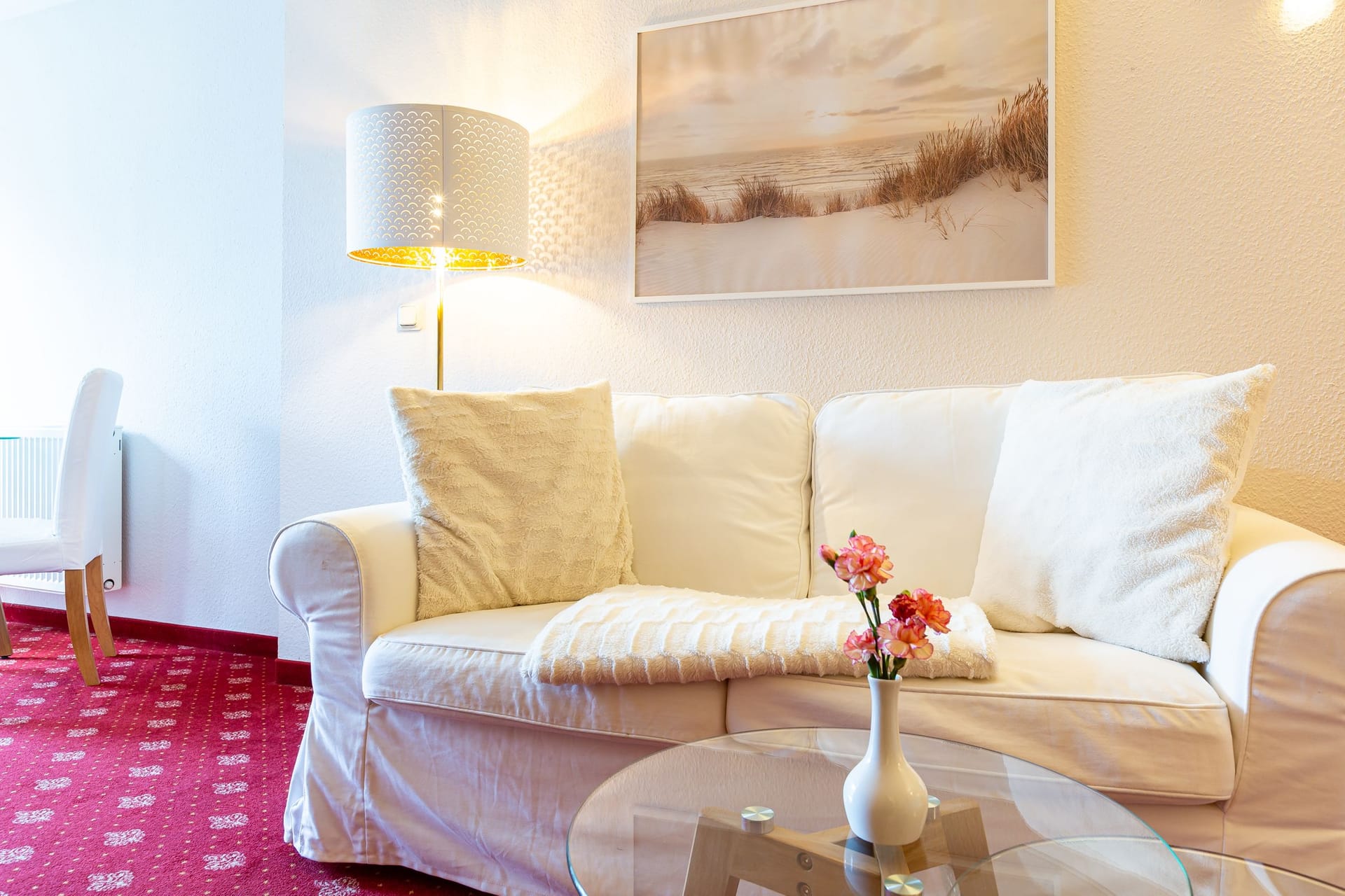 Wohnzimmer mit weißem Sofa und Glastisch