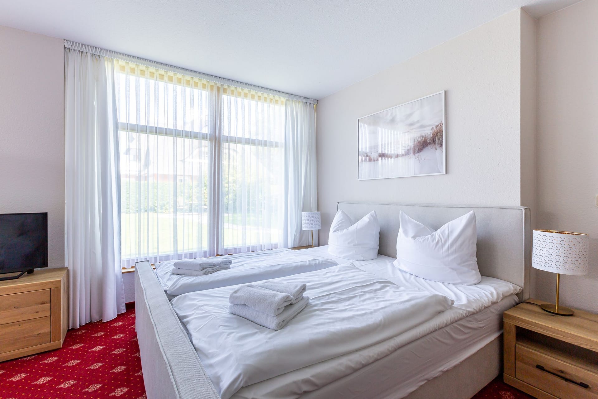 Schlafzimmer mit Doppelbett und Fernseher
