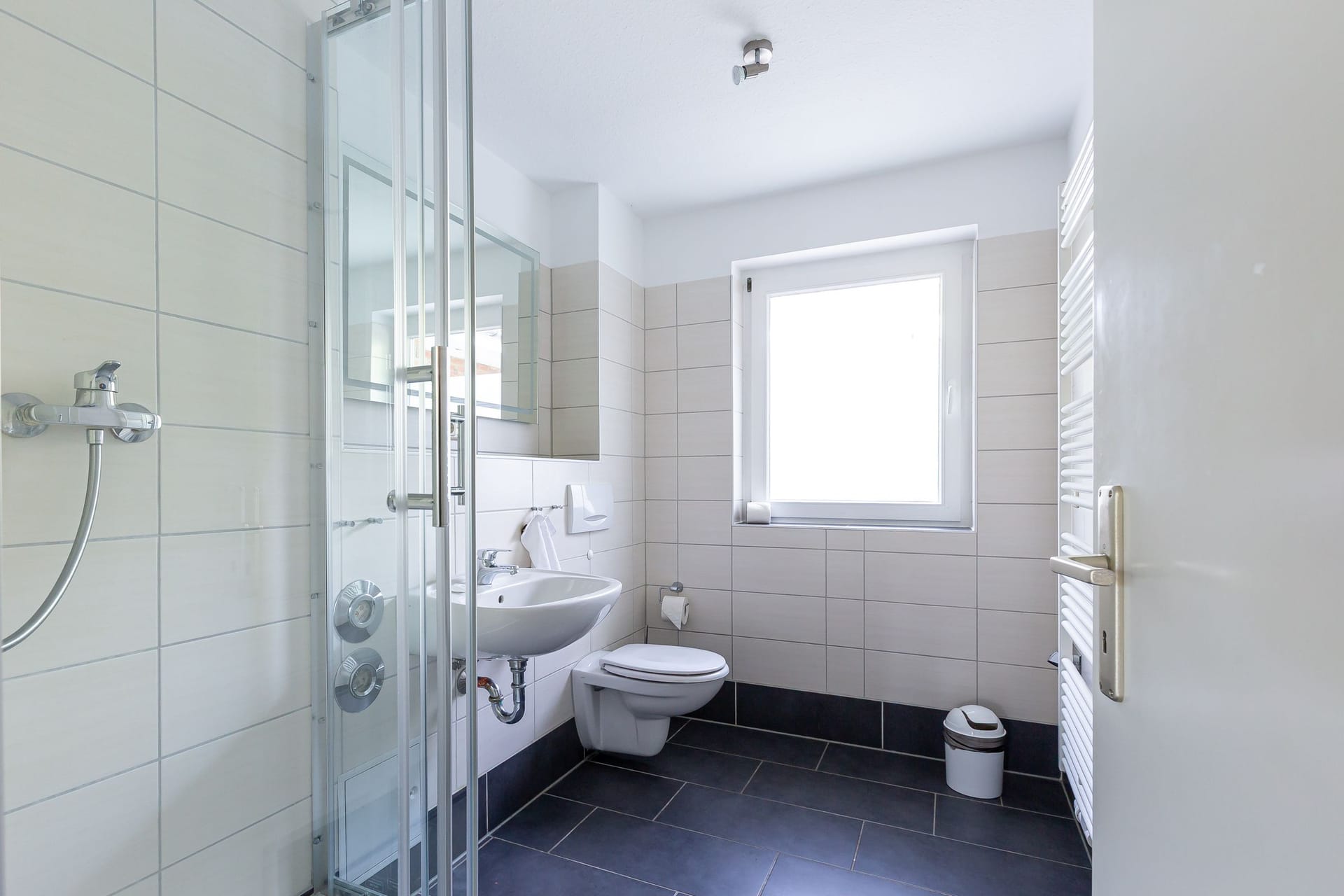 Helles Badezimmer mit Dusche und Fenster