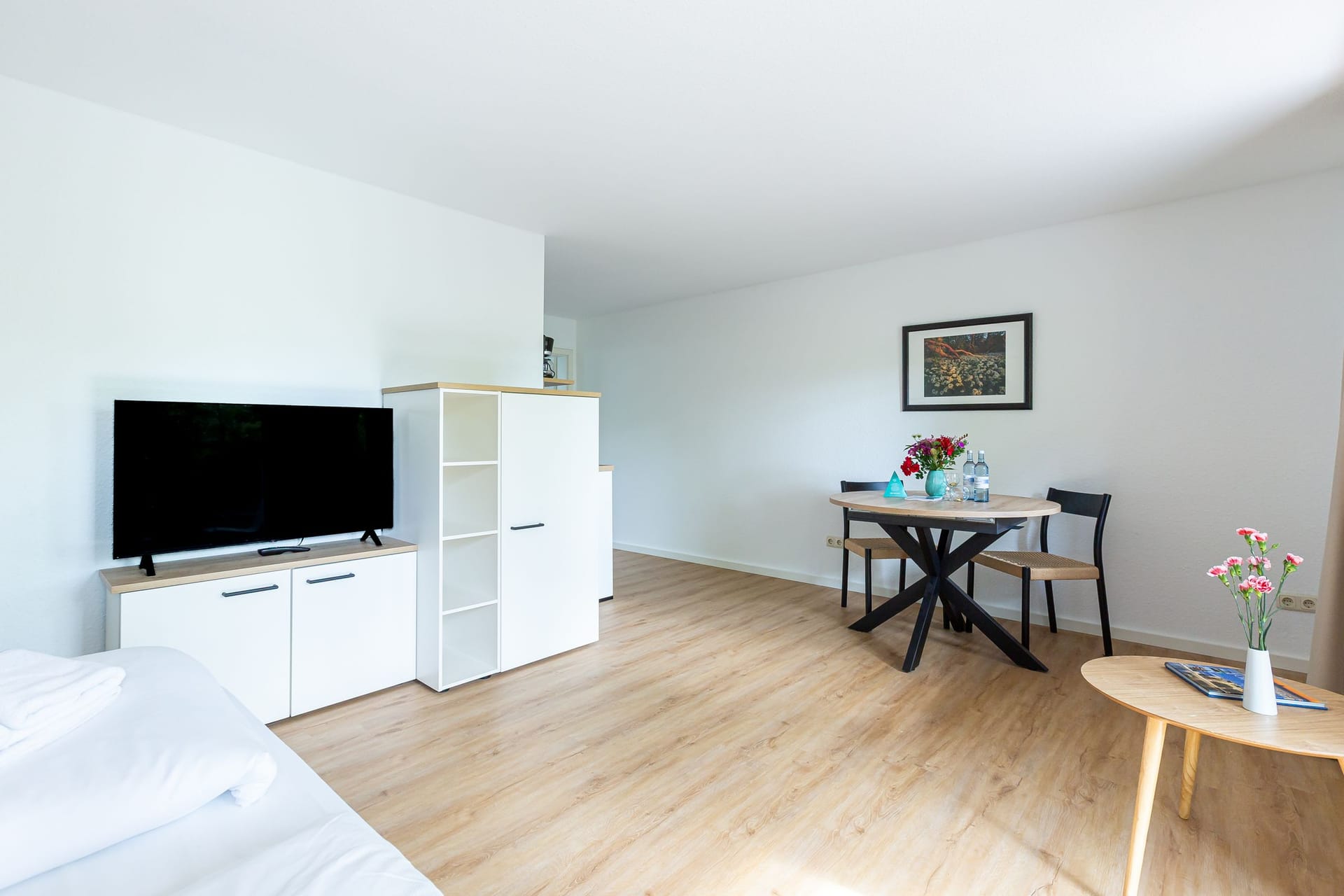 Helles Wohnzimmer mit TV und Essbereich