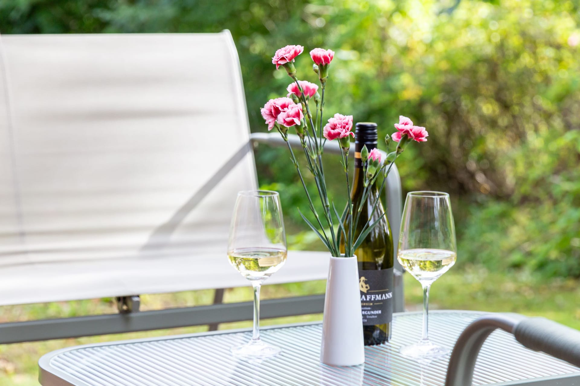 Terrasse mit Tisch, Wein und Blumen